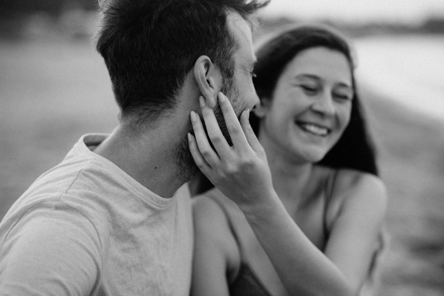 Candid black and white photo showing a joyful interaction at sunset.
