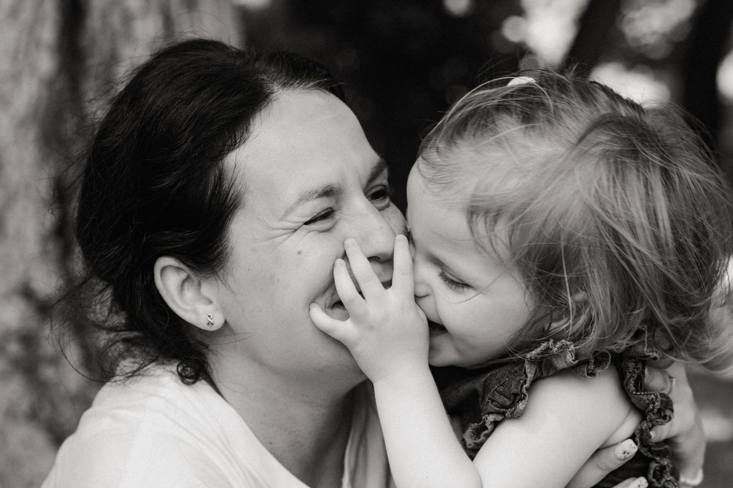 Black and white candid moment of two people sharing an intimate embrace.