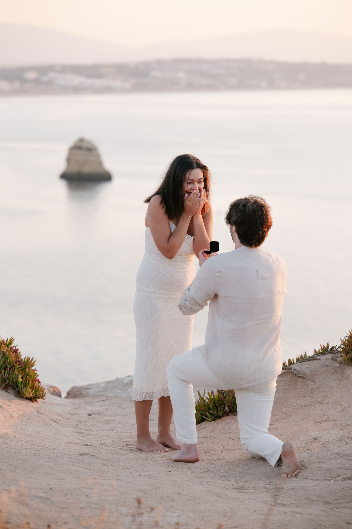 romantic engagement moment overlooking iconic rock formations and cliffs of Lagos at dawn by photographer Algarve