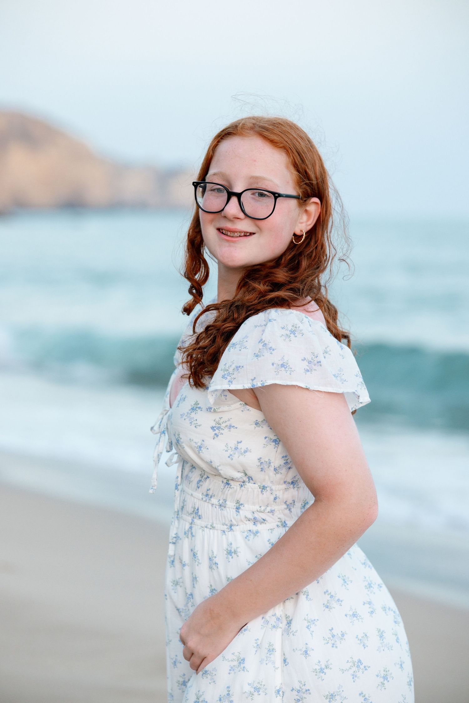 candid moment of daughter laughing while running along the shoreline at Porto de Mós during sunset