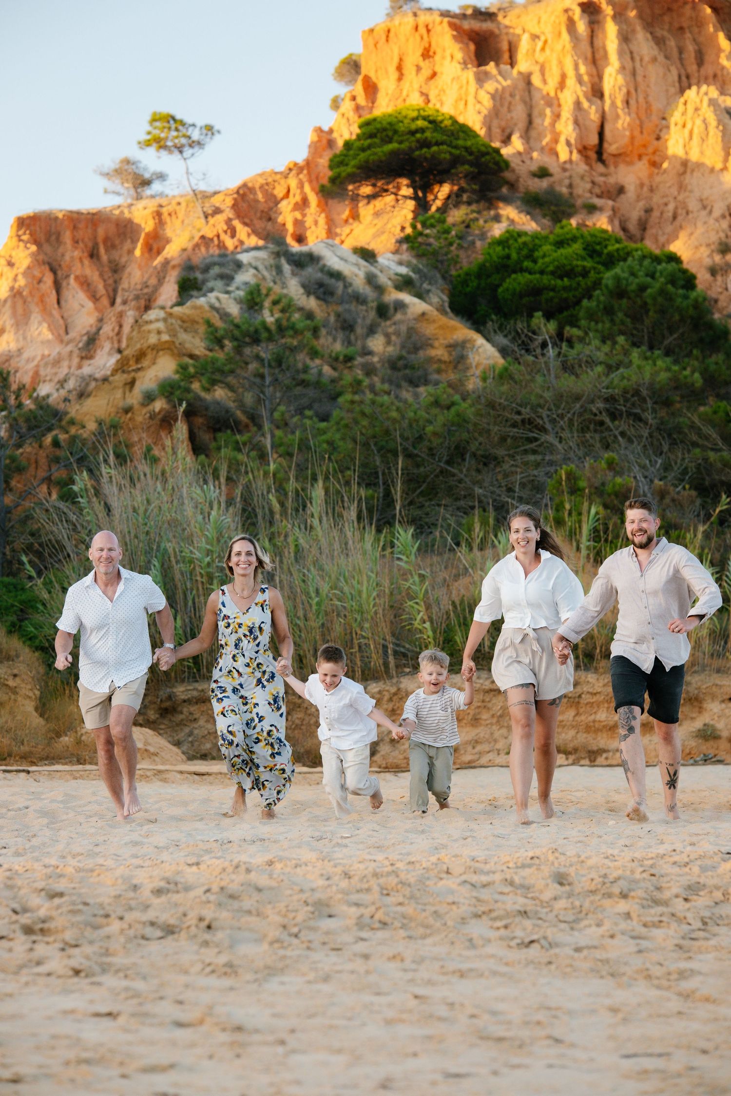 family running on the beach with a stunning backdrop of the pine cliffs
