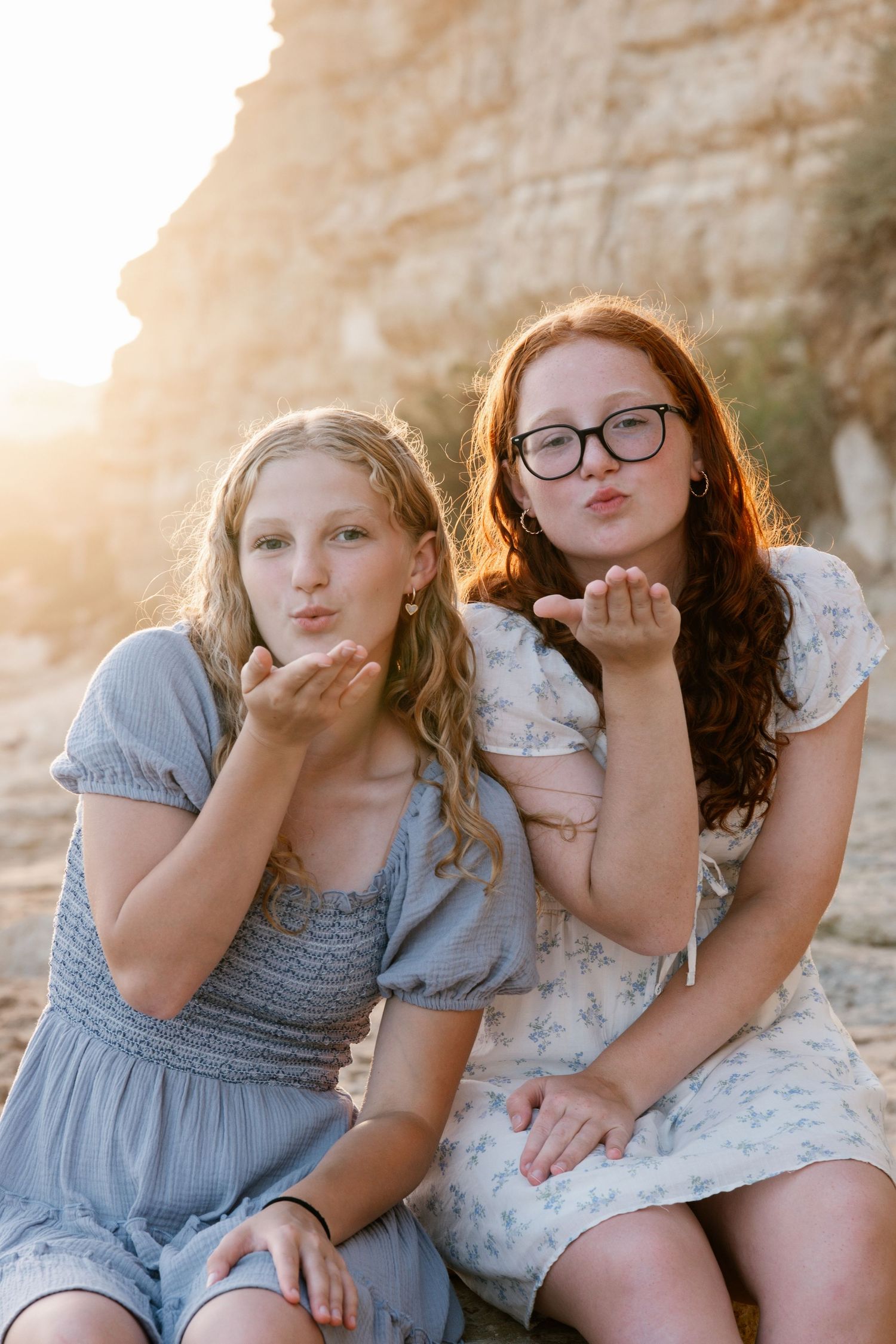 daughter sending a kiss toward the camera at sunset on Praia Porto de Mós