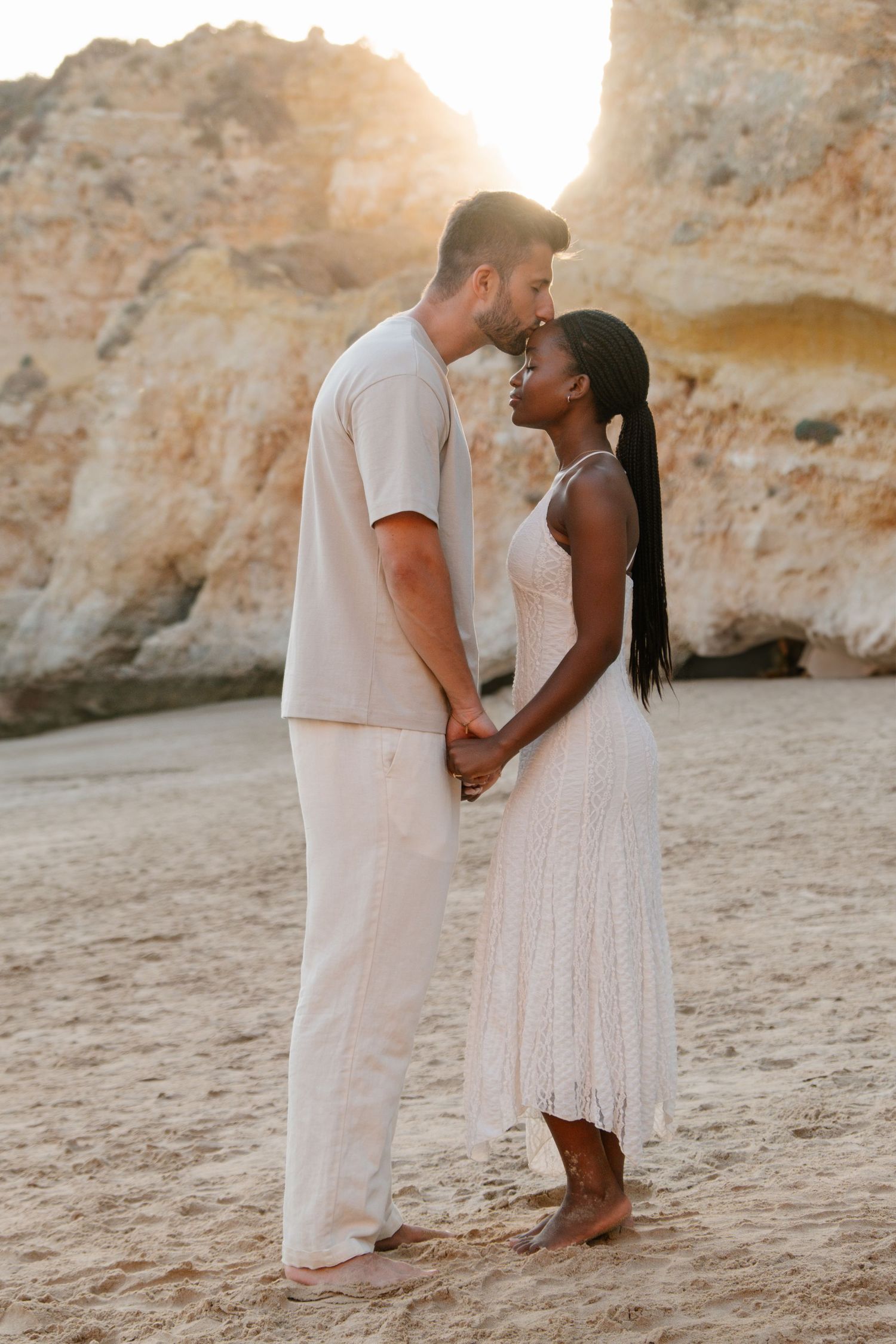 man kisses his wife on the head on the beach of tres irmaos