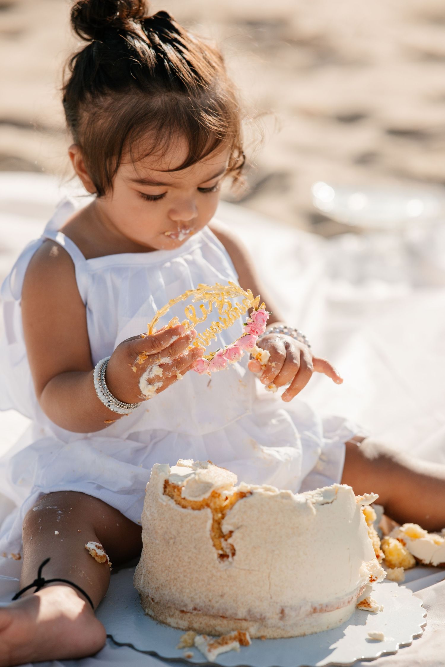 Baby celebrating first birthday on Meia Praia beach sitting on the sand