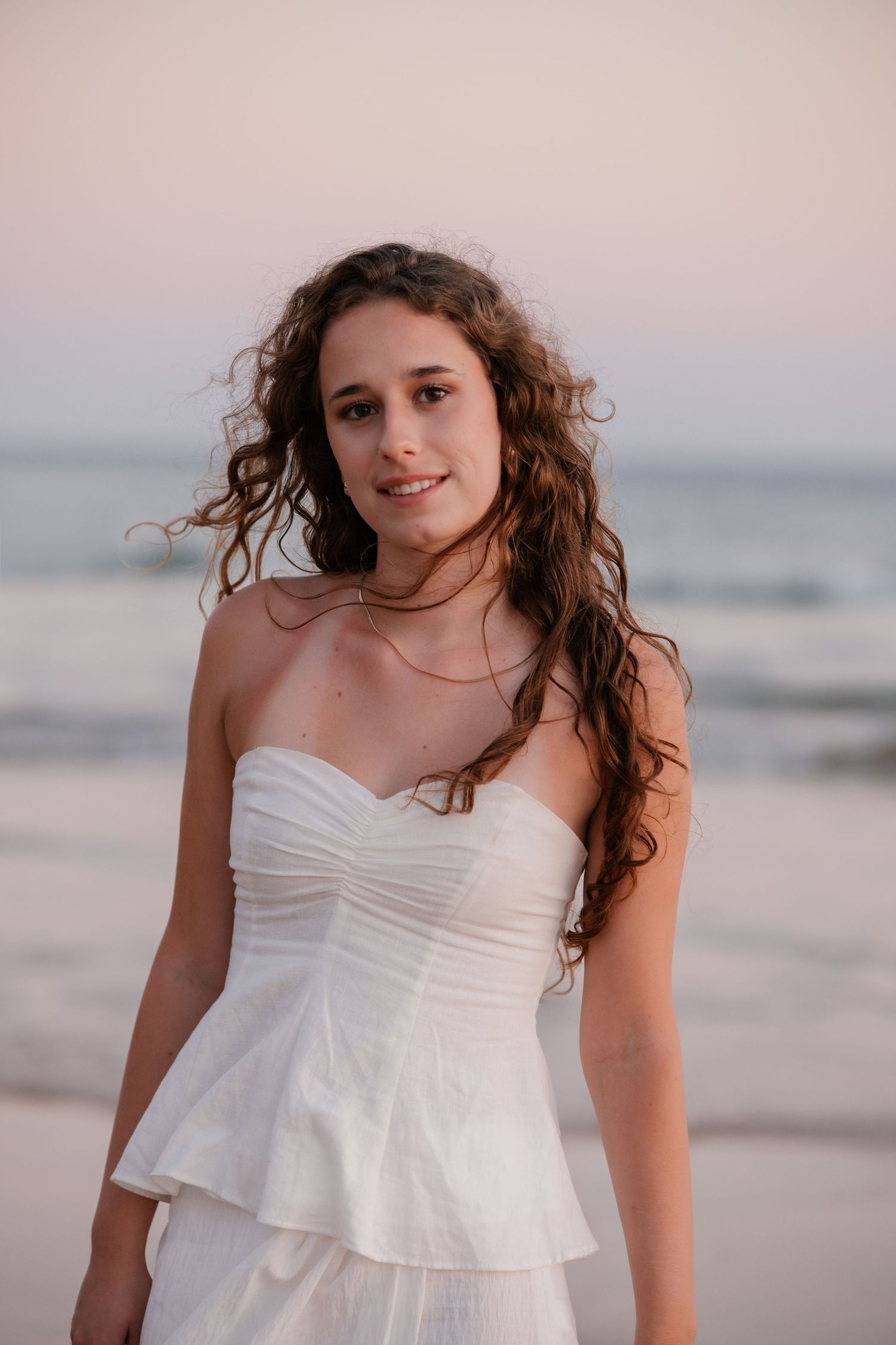 close-up portrait of girl in flowing white dress with warm sunlit tones in Algarve coast