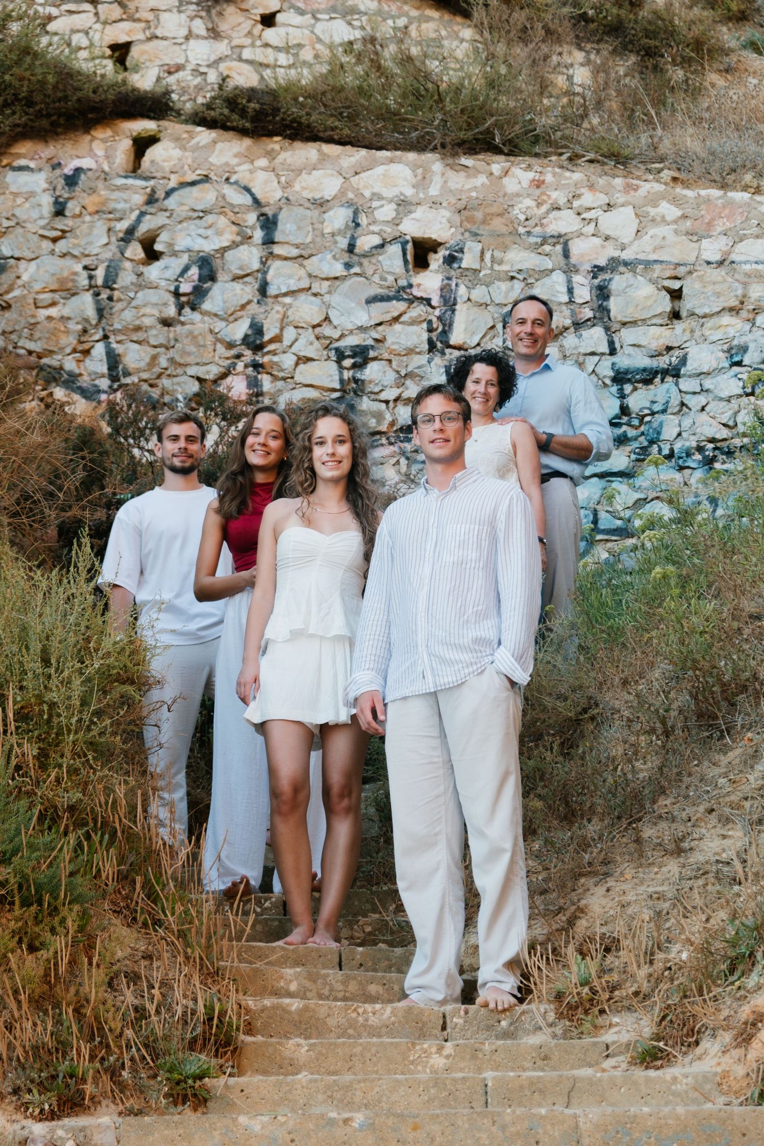 Family photo on natural stairs with sunset light and graffiti