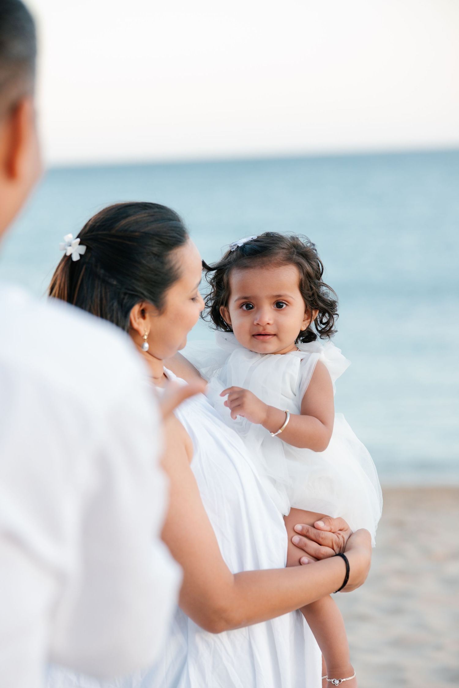 candid family moment during first birthday session with golden light at Praia Porto de Mós