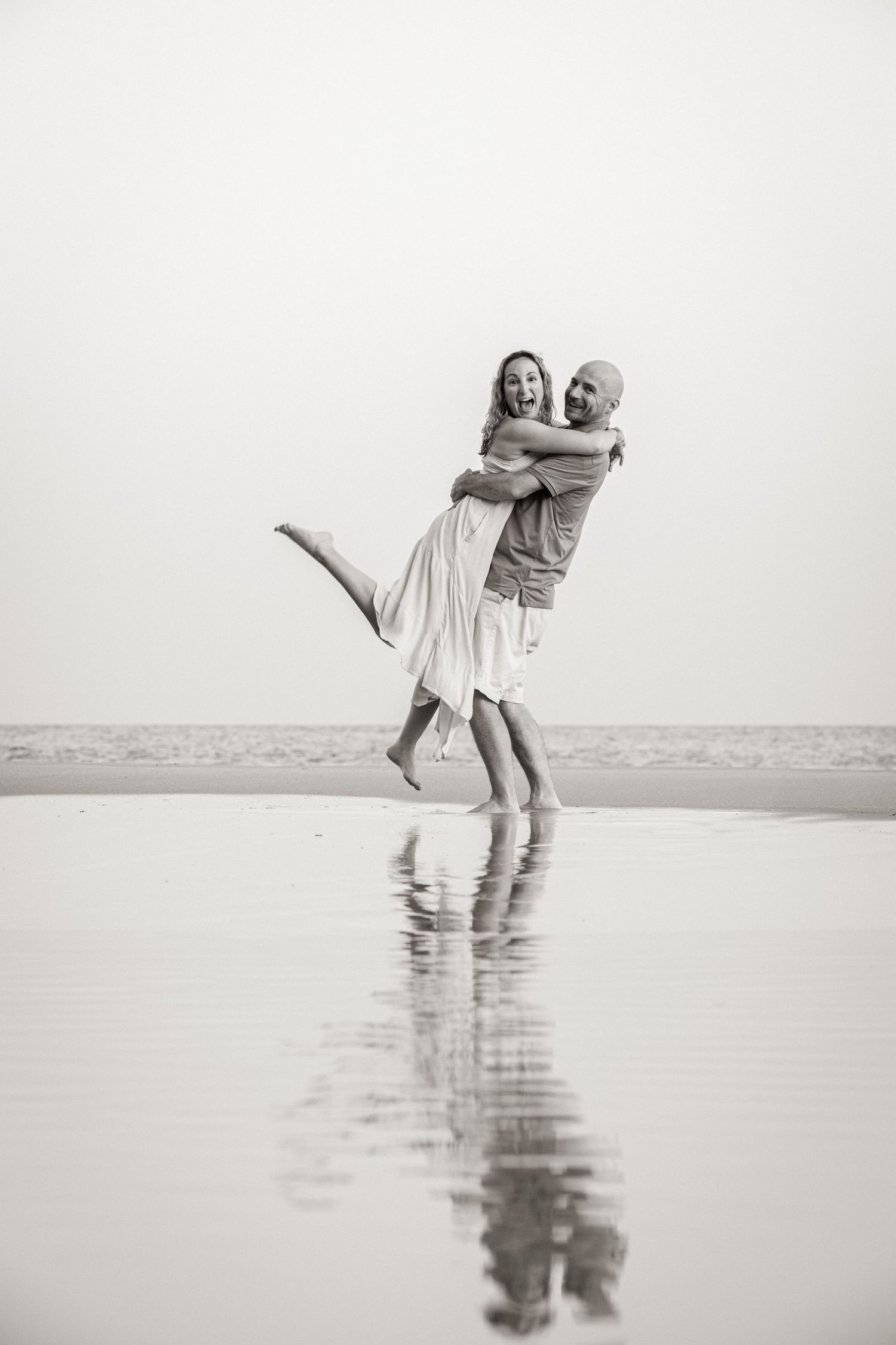 romantic silhouette of parents hugging at sunset on Porto de Mós beach