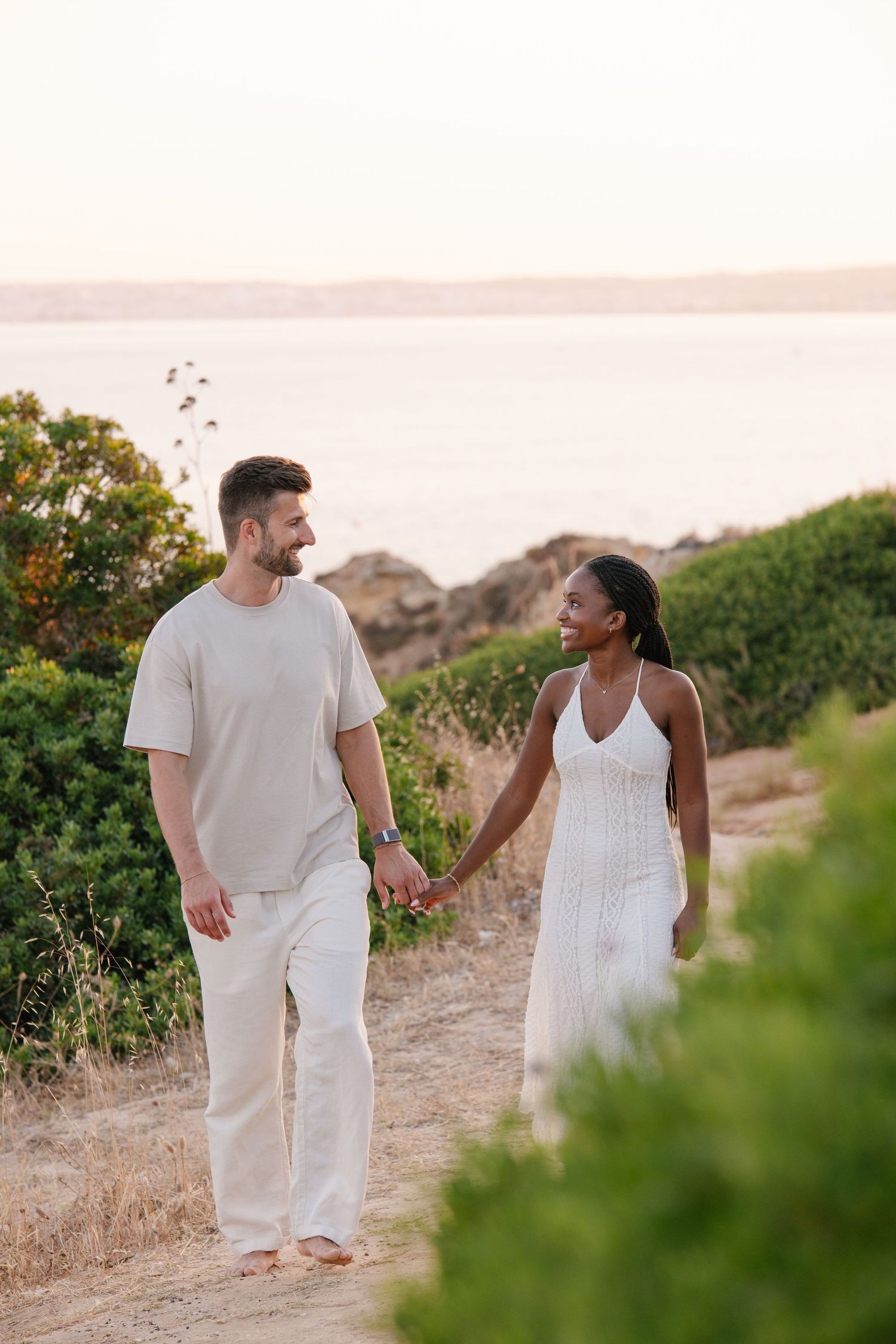 couple walking while watching each other on the cliffs of Portimao