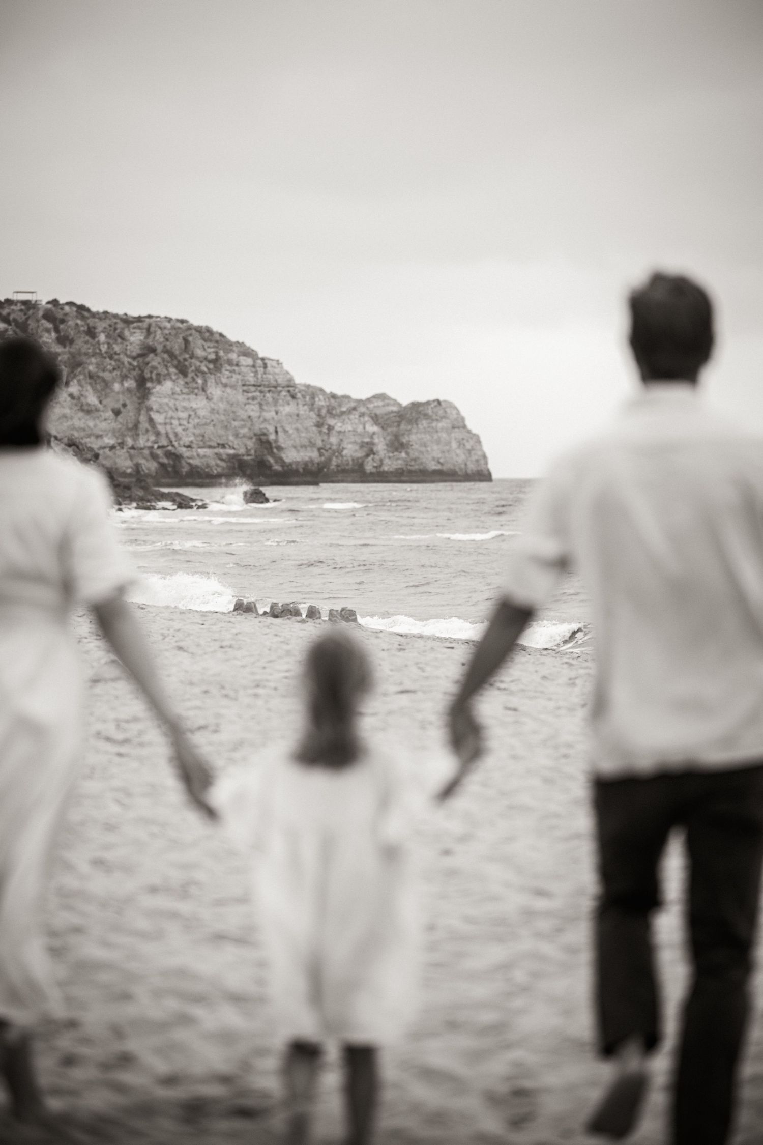 Natural, candid family session on the beach in Lagos with soft morning light and waves.