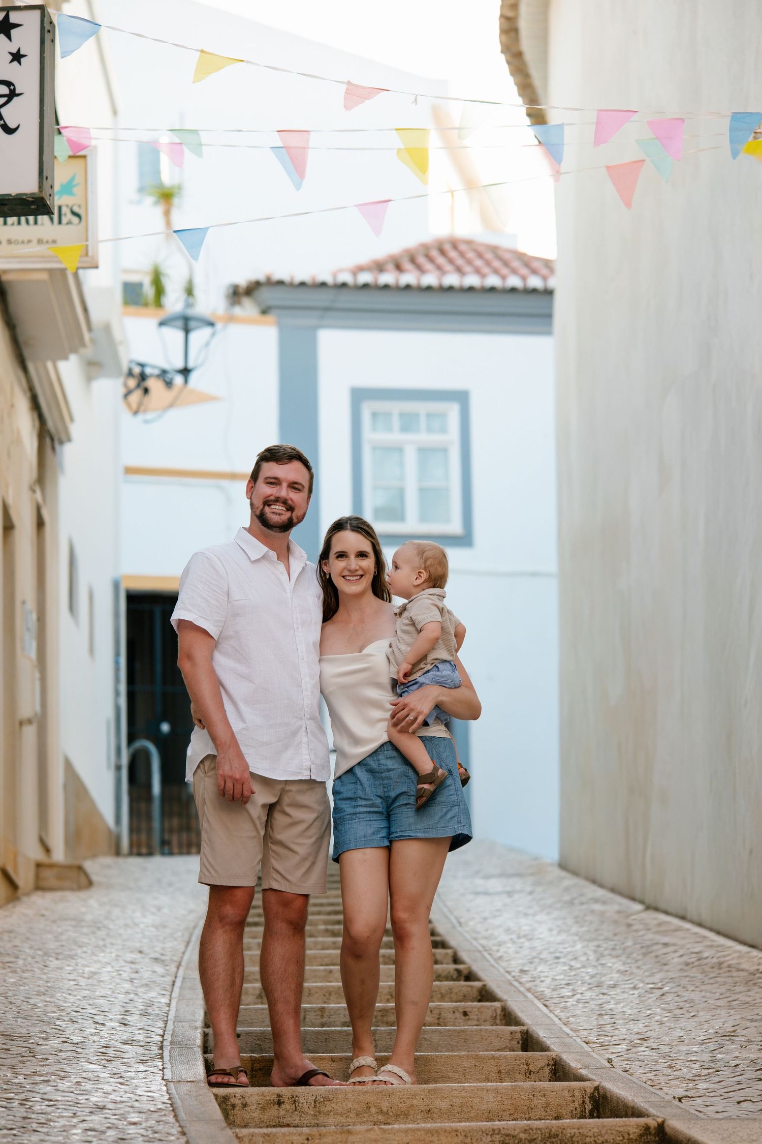 parents walking with toddler in a picturesque Algarve street in Lagos Portugal