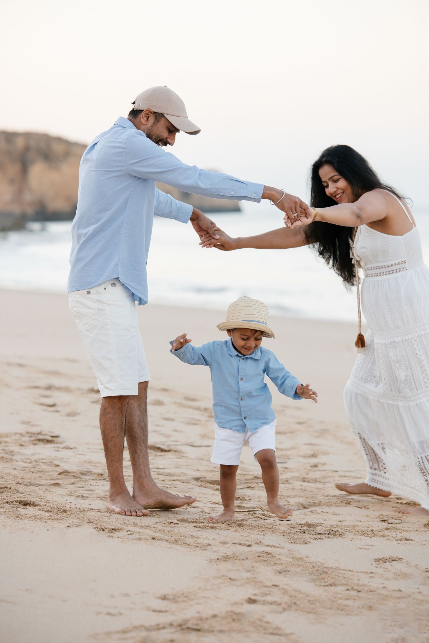 parents playing with son on the beach