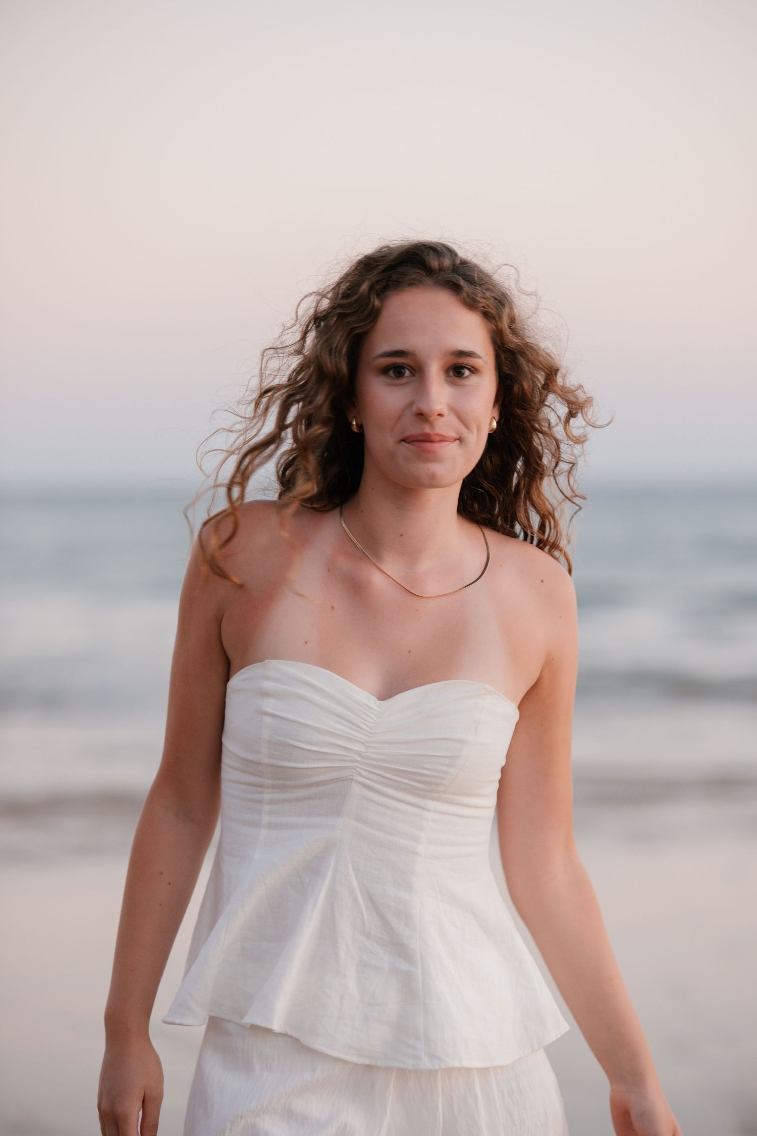 soft golden sunset close-up of girl in white dress with warm light illuminating her face