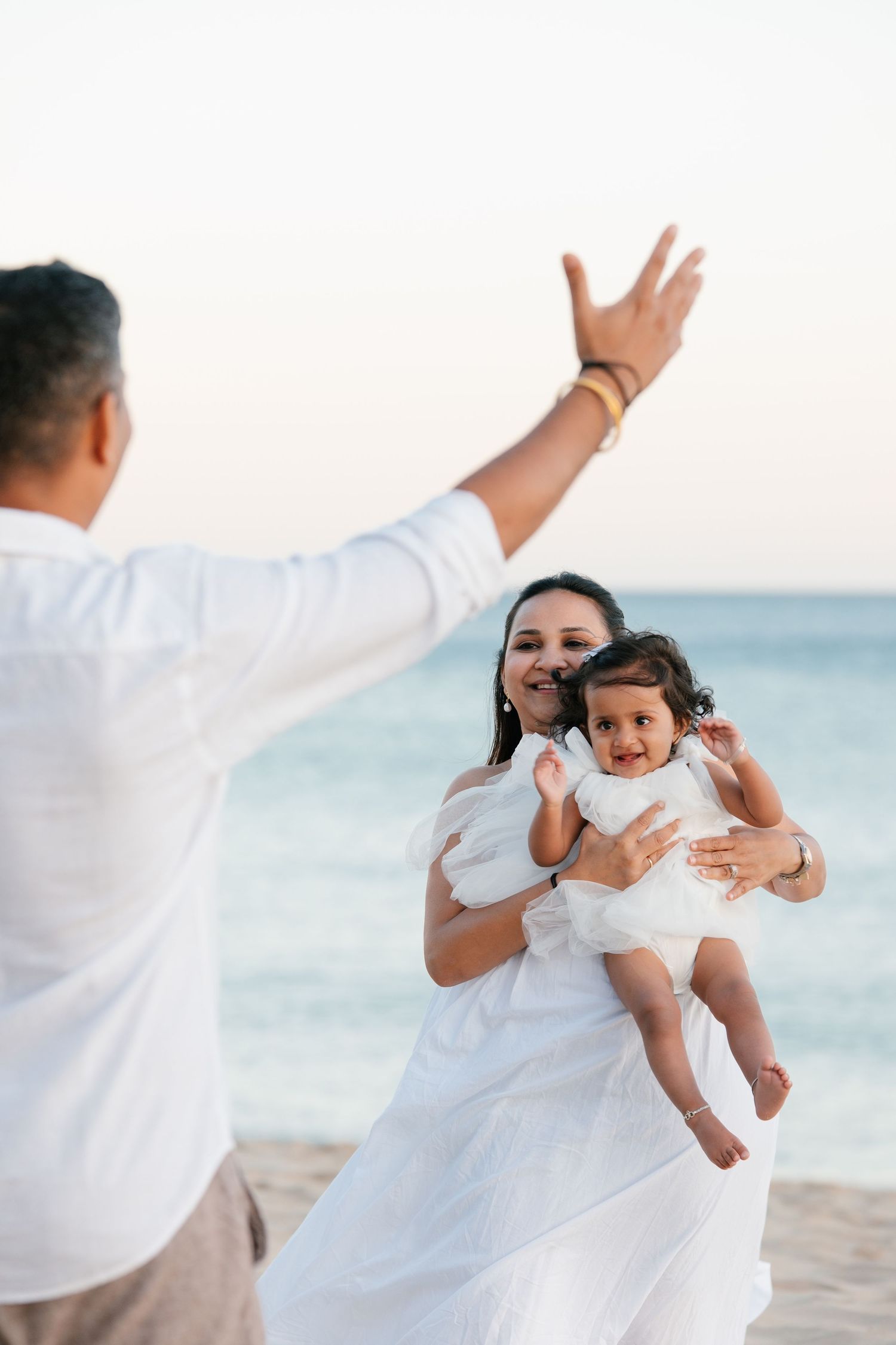 family cuddling together on Porto de Mós cliffs celebrating baby's first birthday