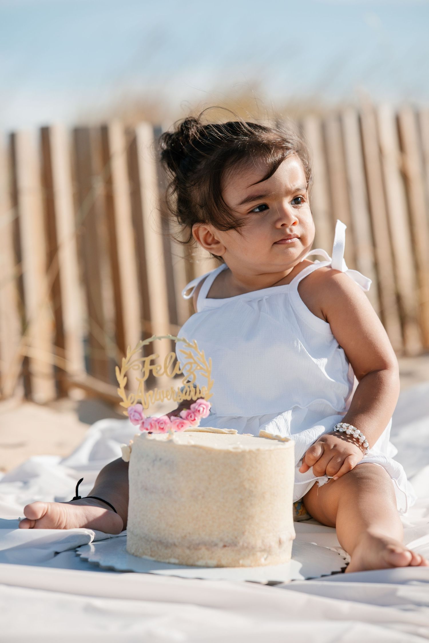 Baby smiling while playing with her birthday cake