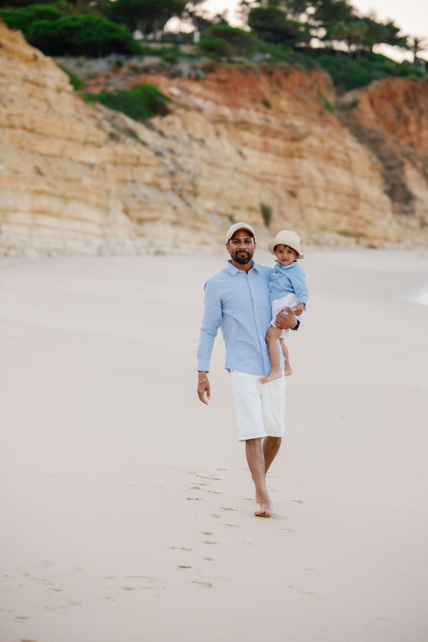 father and son walking on the beach in beautiful algarve backdrop