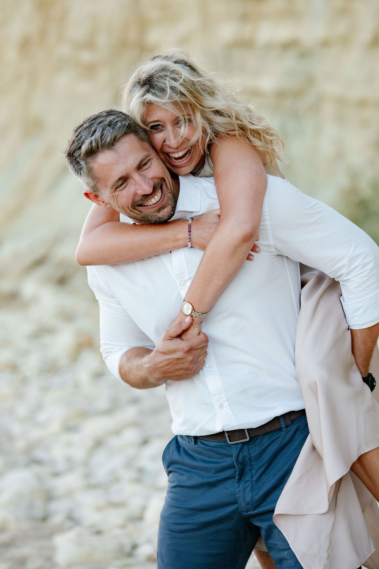 Romantic moment of couple hugging on sandy beach