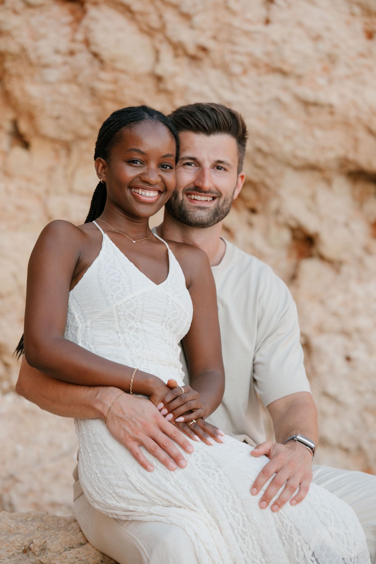 couple pose while sitting together and smiling