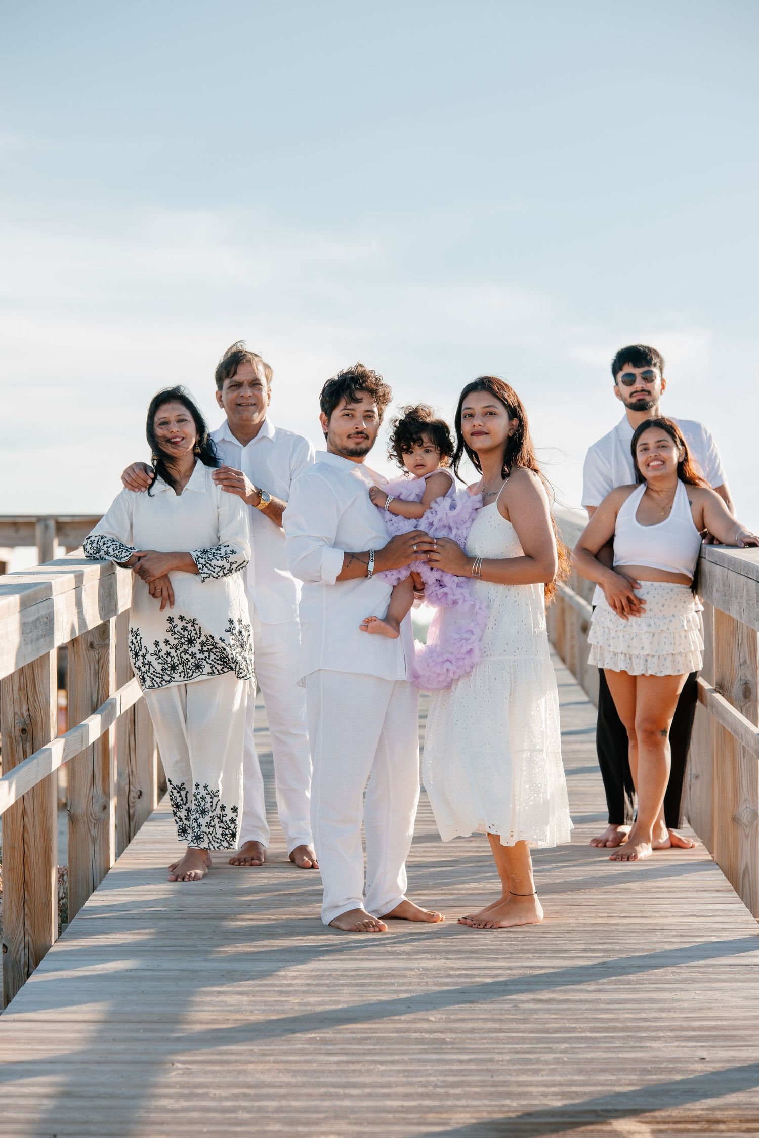 Family  holding hands with baby between them at Meia Praia.