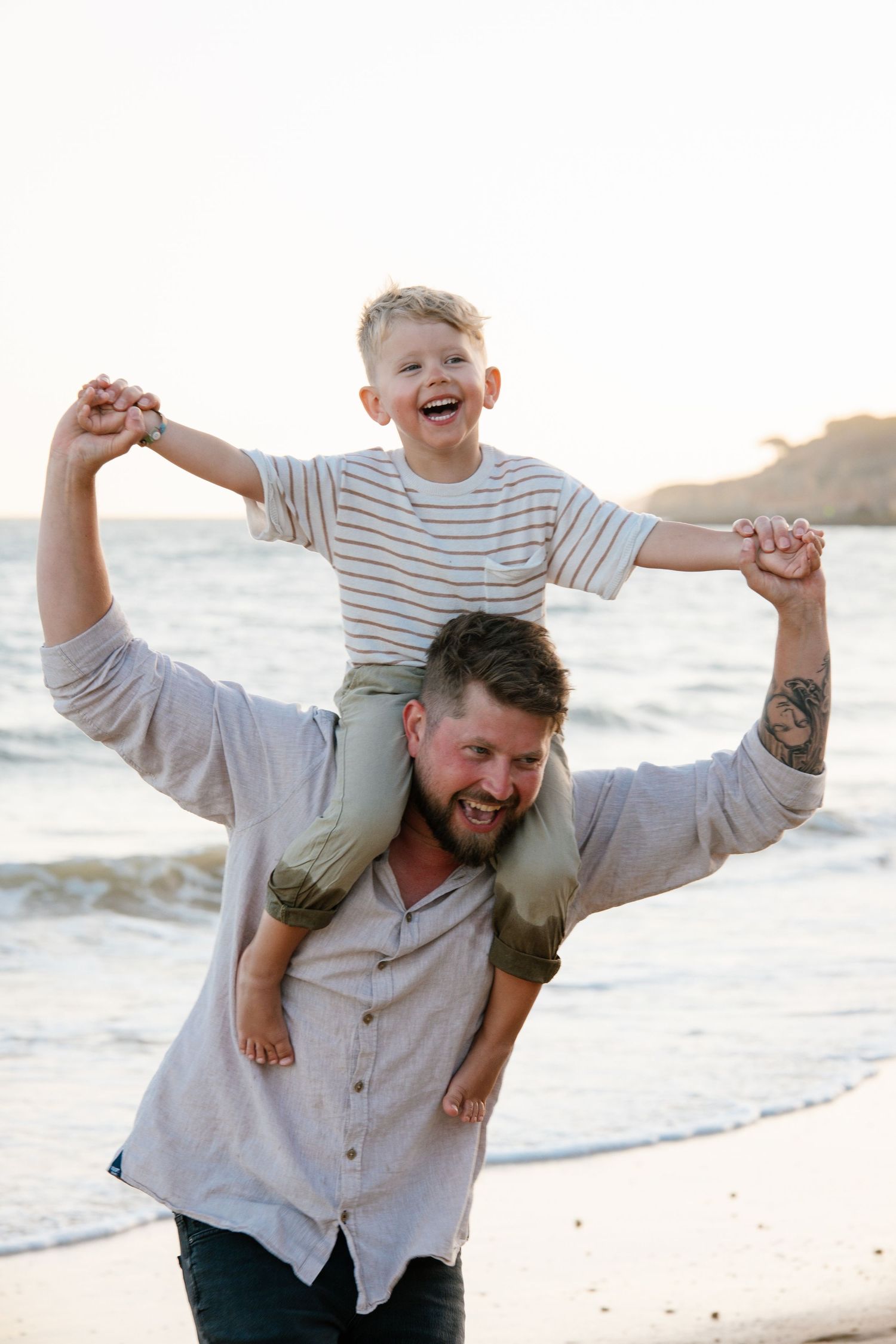 funny moments on the beach with father running on the beach with son on his shoulder