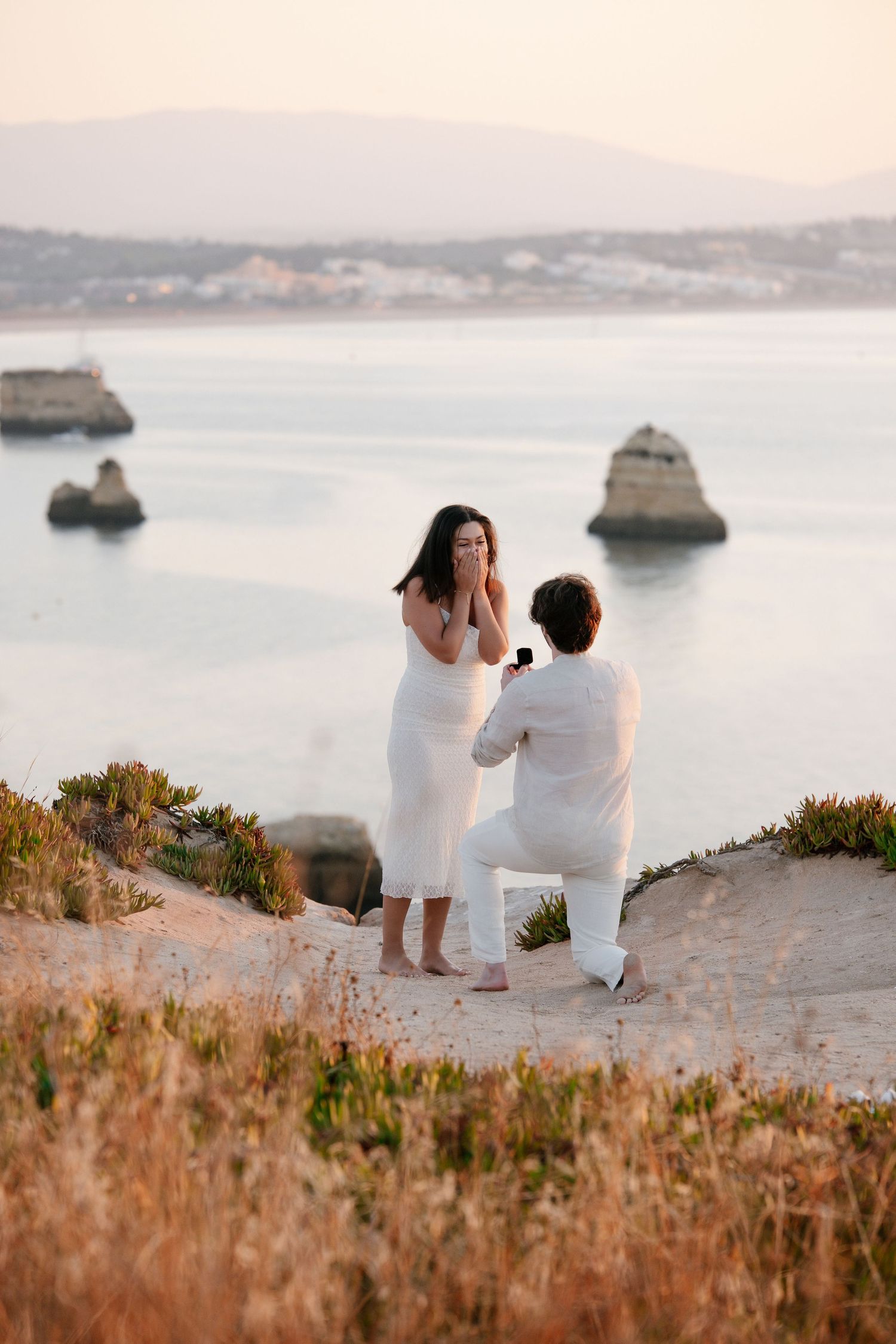 emotional sunrise engagement moment on cliff viewpoint at Praia da Camilo, Algarve