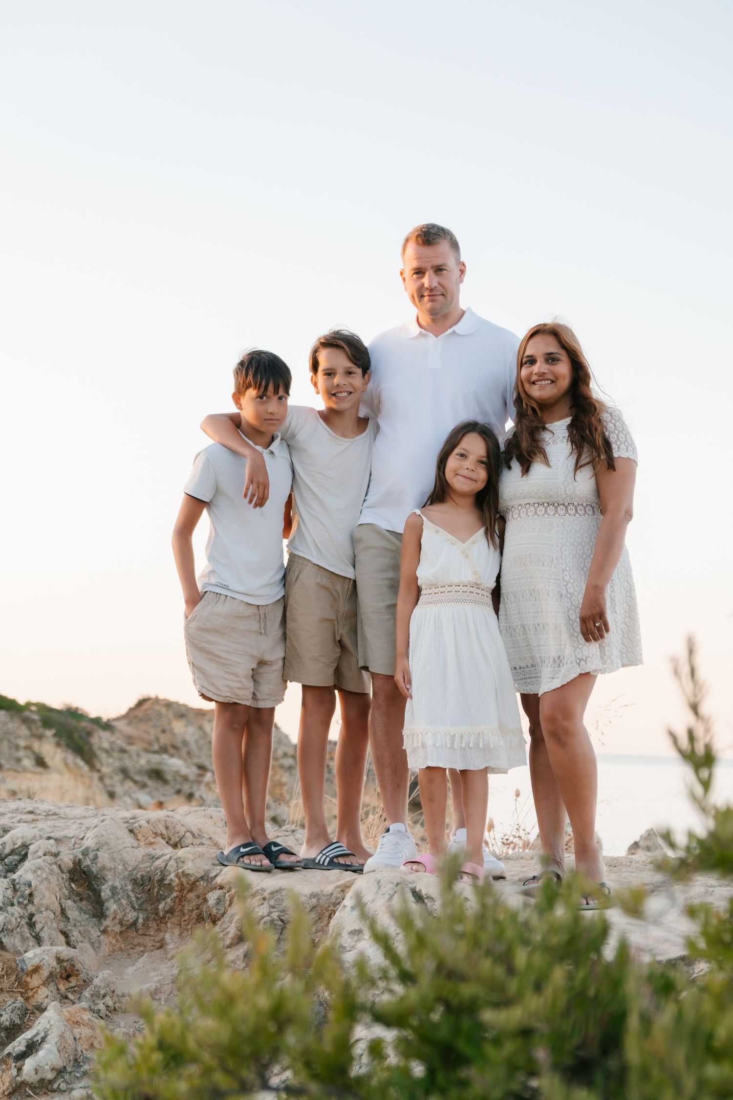 Family group photo on coastal cliffs with ocean views in the background.