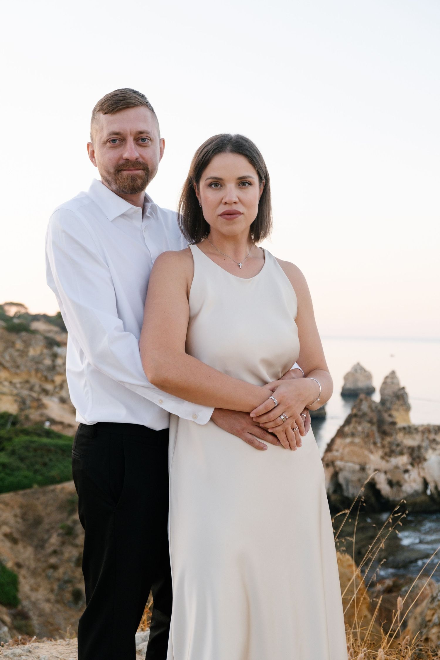 natural candid of couple cozy together on cliffs at Três Irmãos beach during sunrise