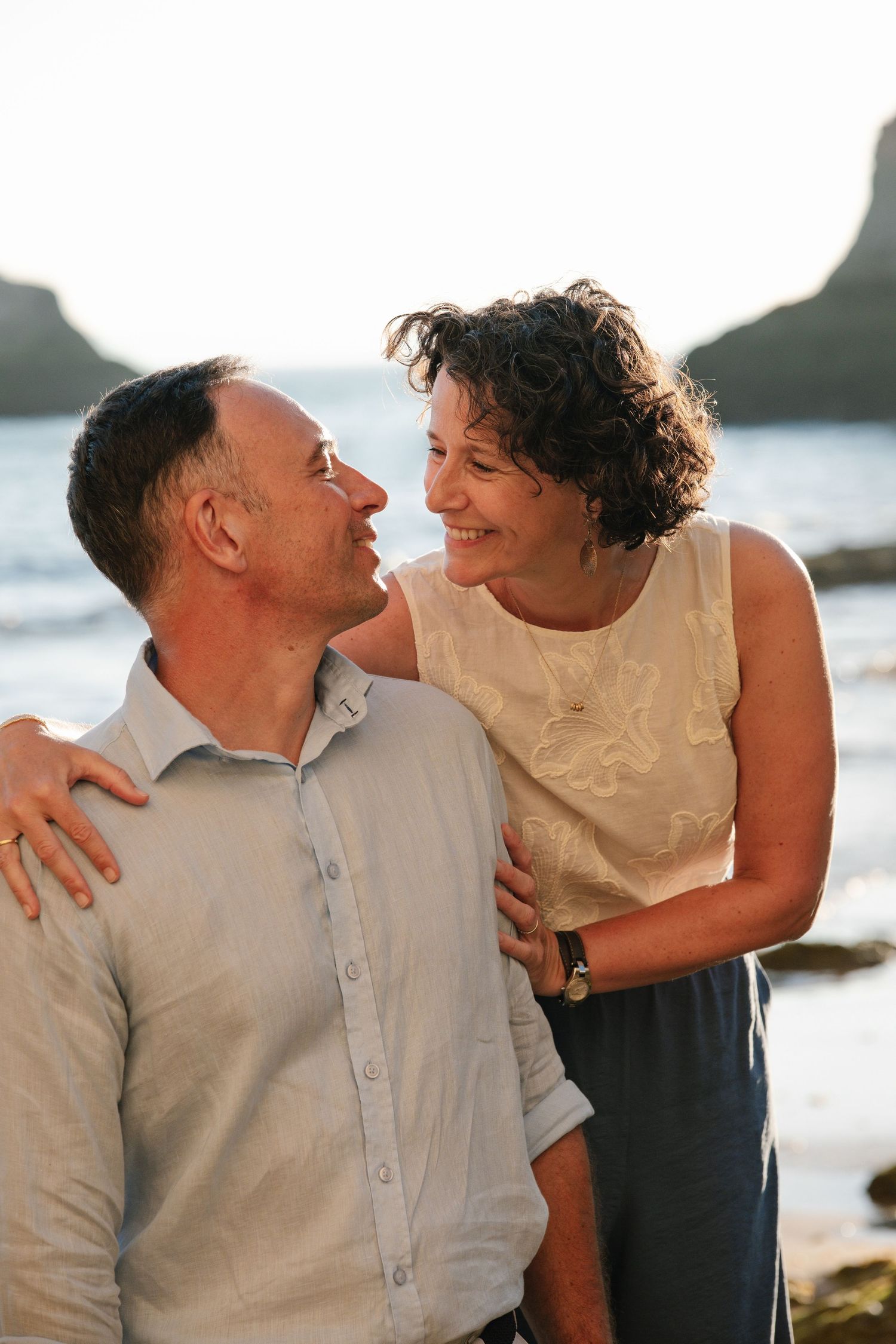 lovely moment of parents holding each other on the beach during sunset