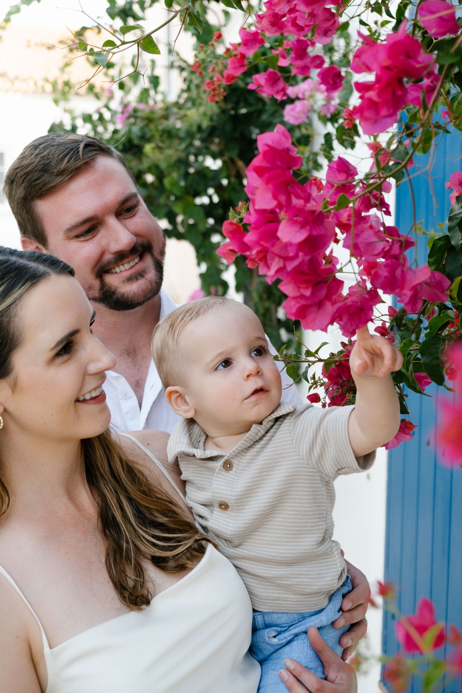 toddler looking up at flowers on a charming Algarve street with tiled façades and white walls
