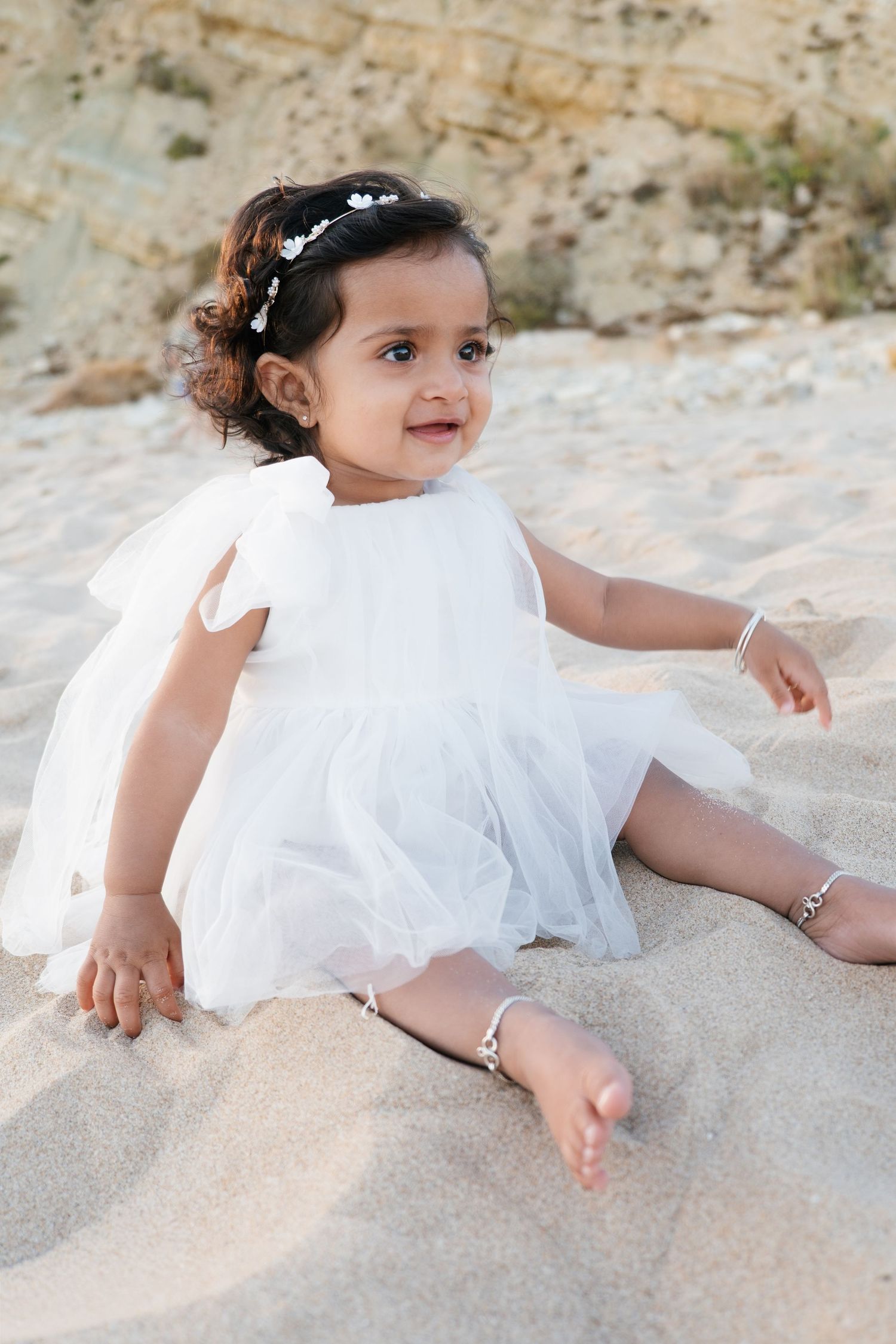 baby sitting in the sand at Praia Porto de Mós during first birthday photoshoot