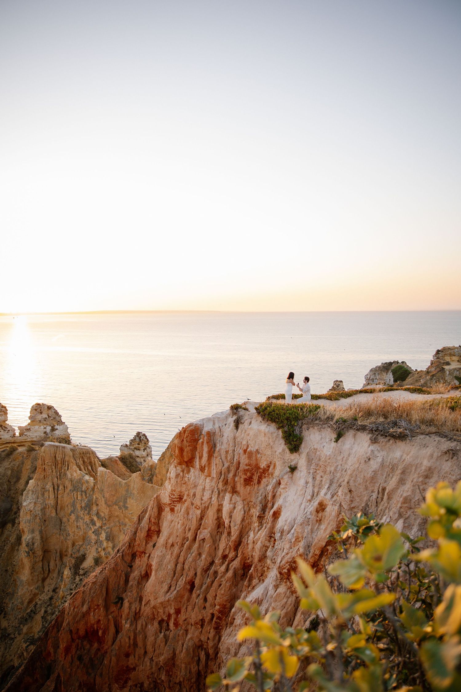 epic sunrise proposal on the cliffs at Praia da Camilo in Lagos with golden light