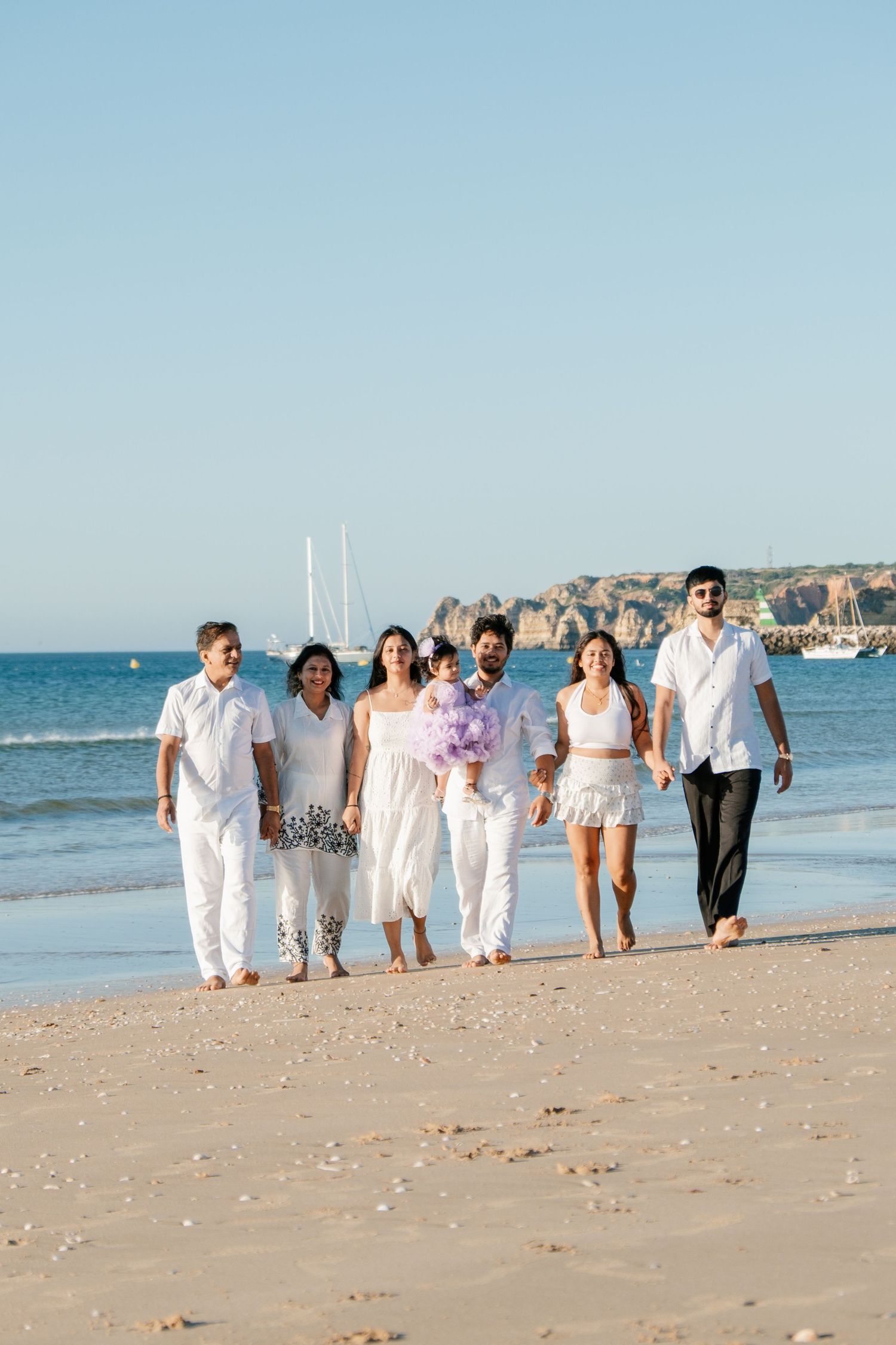 Family walking with baby between them at Meia Praia.