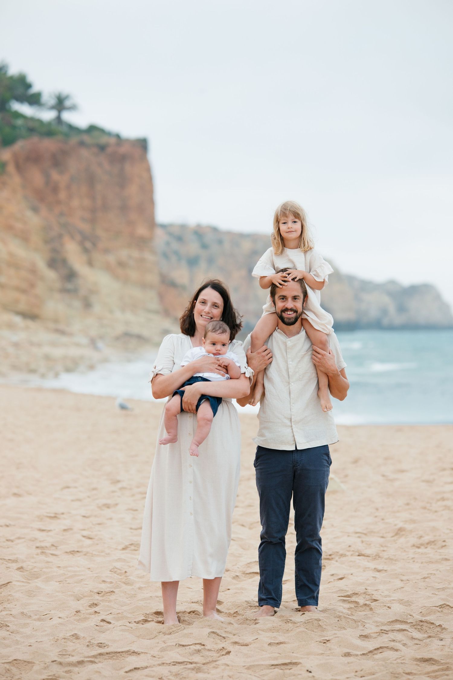 Candid family photoshoot on the beach in Lagos at sunrise with natural moments and ocean backdrop.