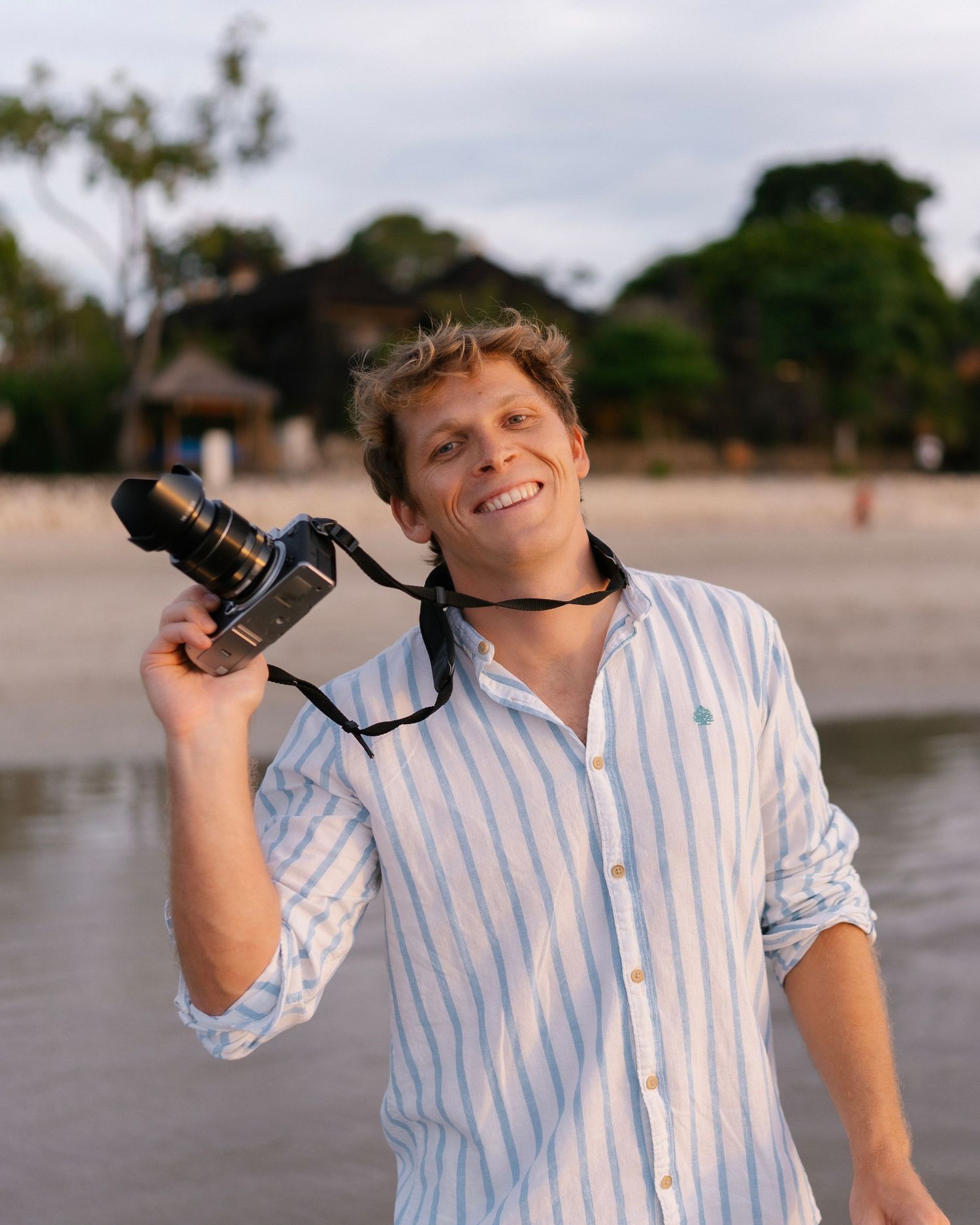 Photographer holding his camera in his hand and smiling