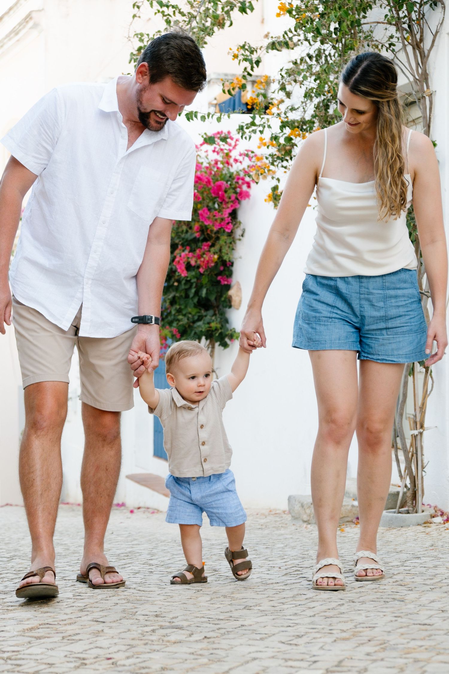 family walking together on a sunlit street with traditional tiled façades in the background