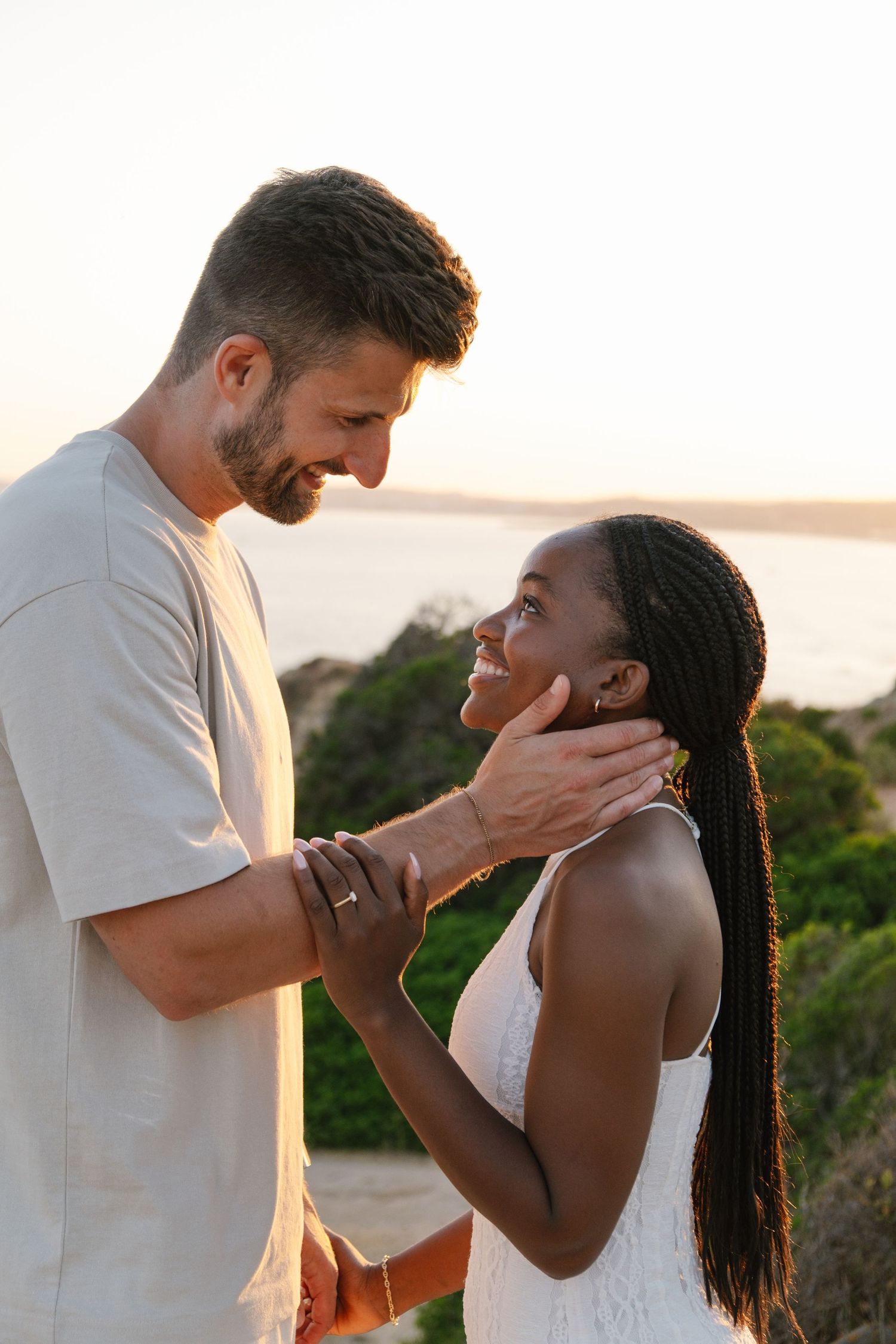 Man is touching the face of is girlfriend on a beautiful setting in the algarve