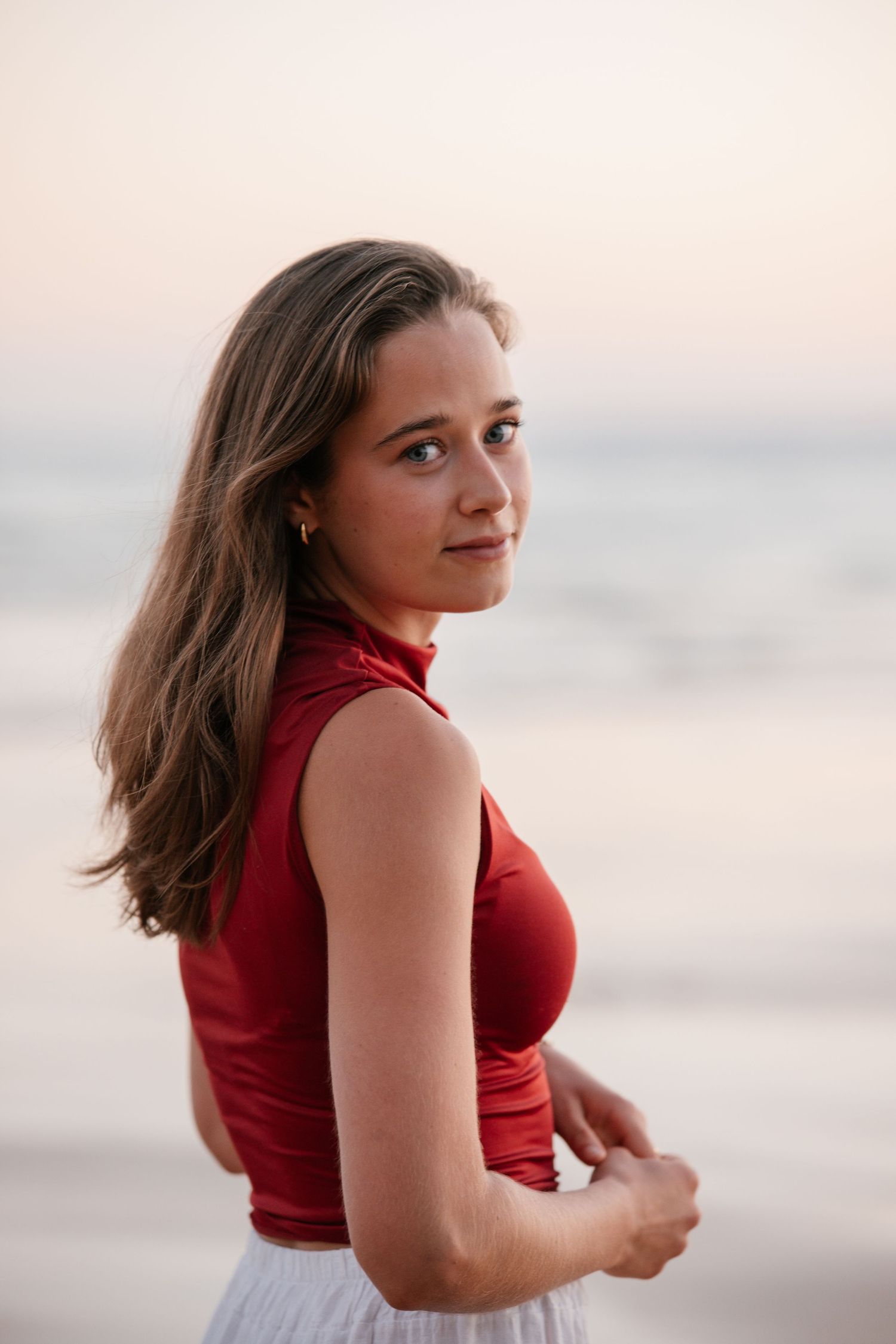 beautiful close-up portrait of girl at Praia Três Irmãos during sunset wearing a red t-shirt