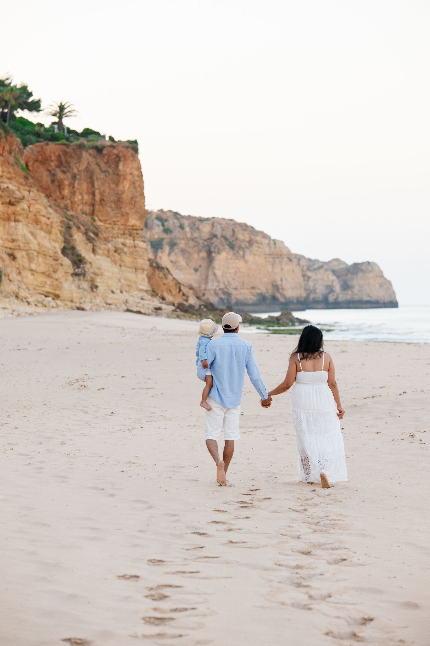 beautiful family walk on the beach with cliffs in the background in the algarve