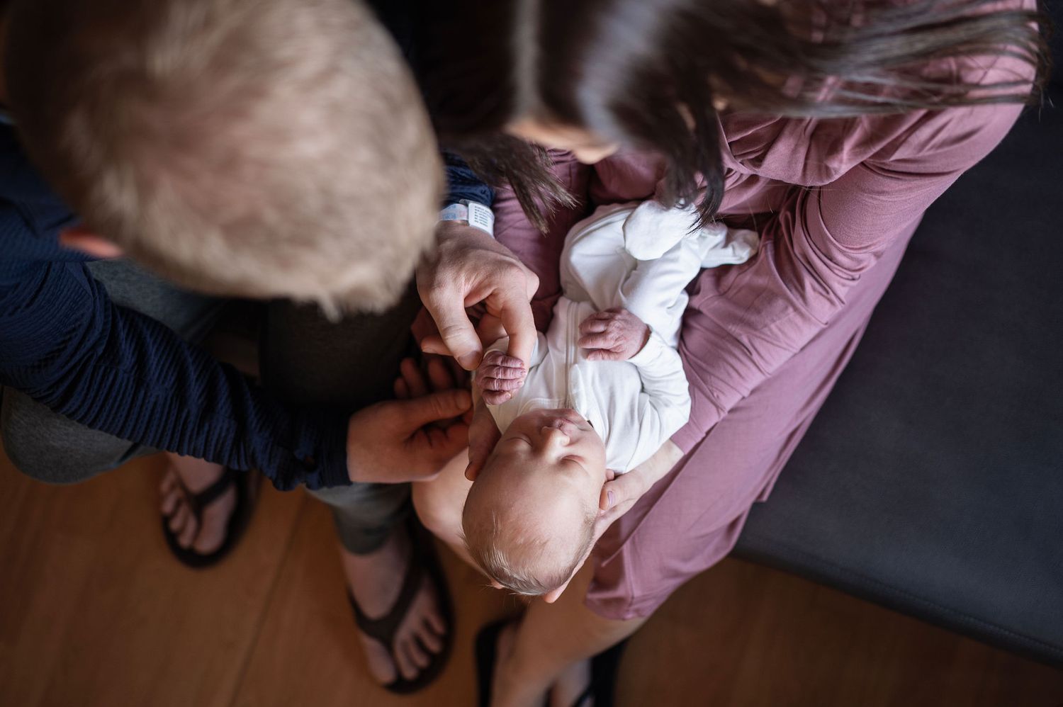 Overhead view of parents holding their newborn close, soaking in quiet, heart-melting moments together.