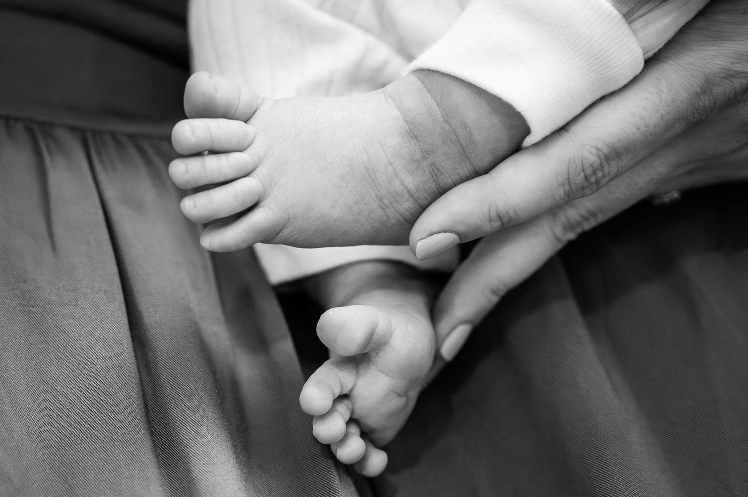 Black and white photo of newborn toes in mom’s hands, captured during a Fresh 48 hospital photography session.