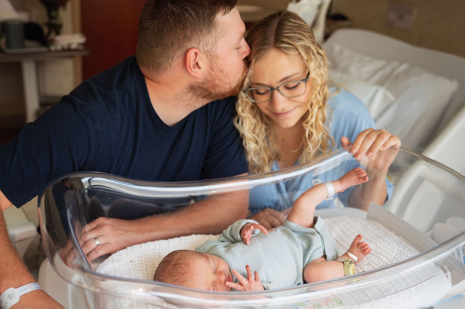 Fresh 48 hospital session—mom and dad adoring newborn in bassinet in Columbus hospital