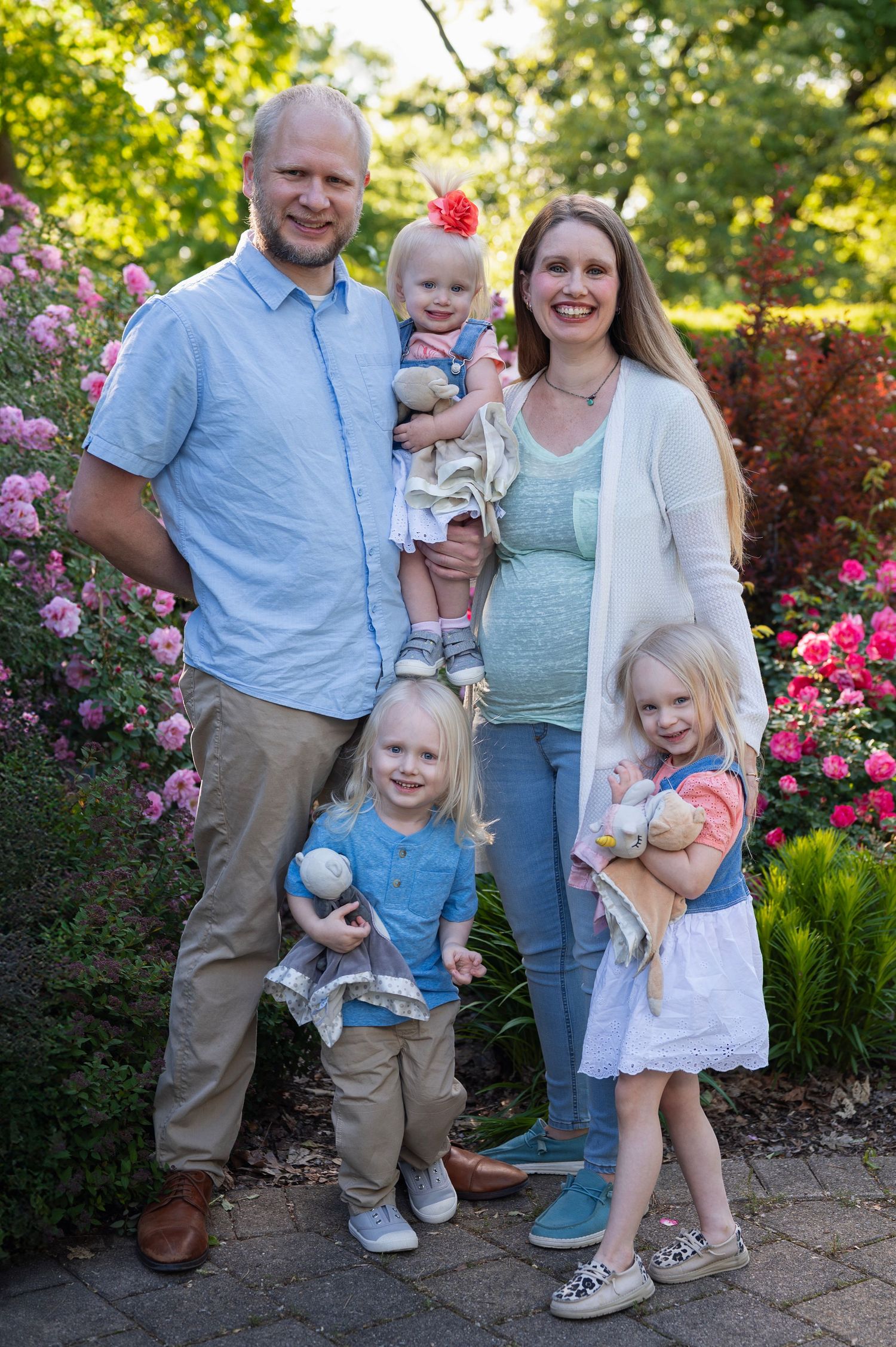 Family of five smiling in rose garden with bright flowers at Park of Roses in Columbus