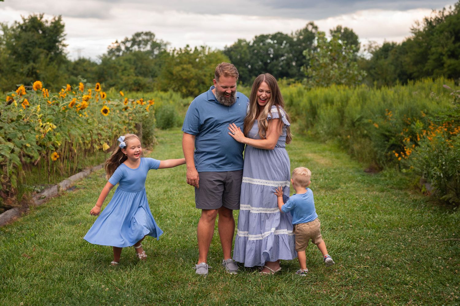 Joyful family surrounded by sunflowers as children laugh and run, capturing playful, connection-filled family photography.