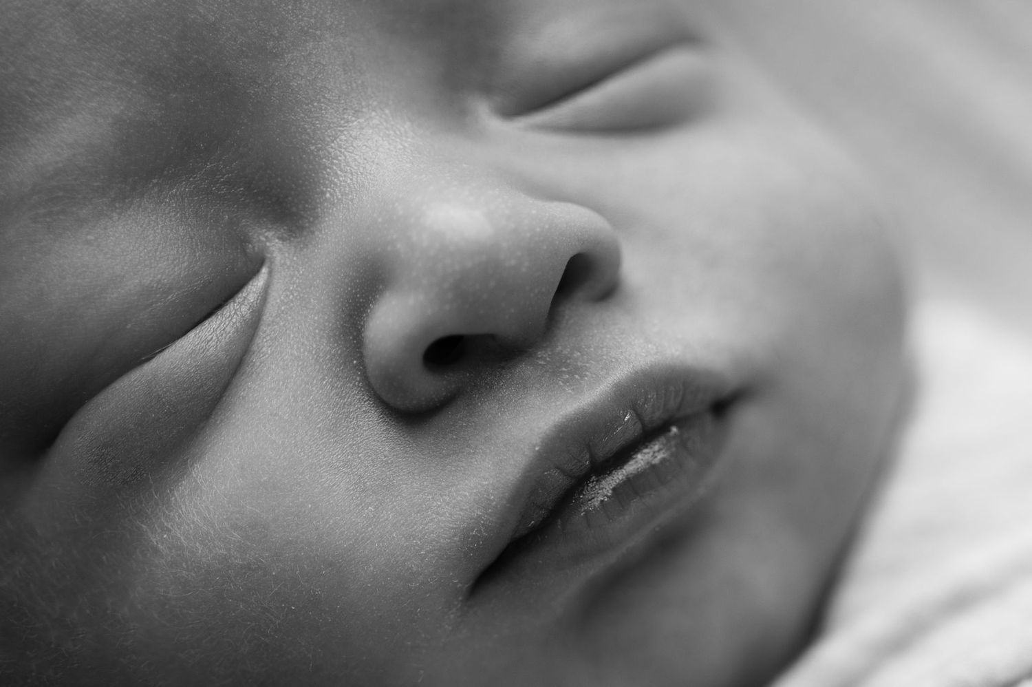 Black and white closeup of baby’s lips and lashes. Timeless newborn photo by your Westerville newborn photographer.