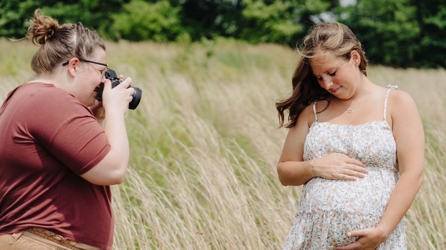 Westerville maternity photographer capturing a tender moment in golden summer grass.