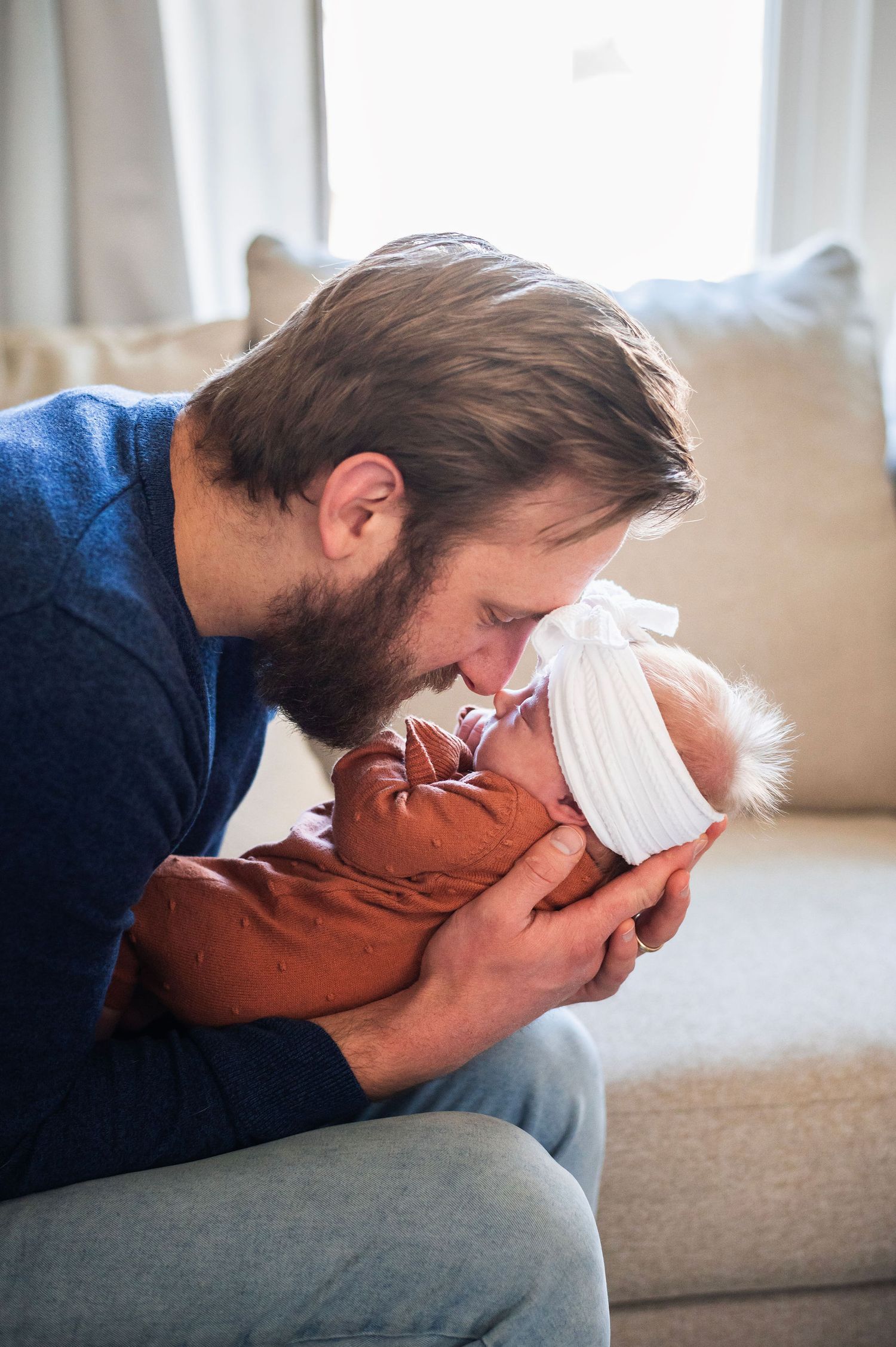 Dad touches noses with his newborn girl in cozy in-home session—Boundless Joy Photography