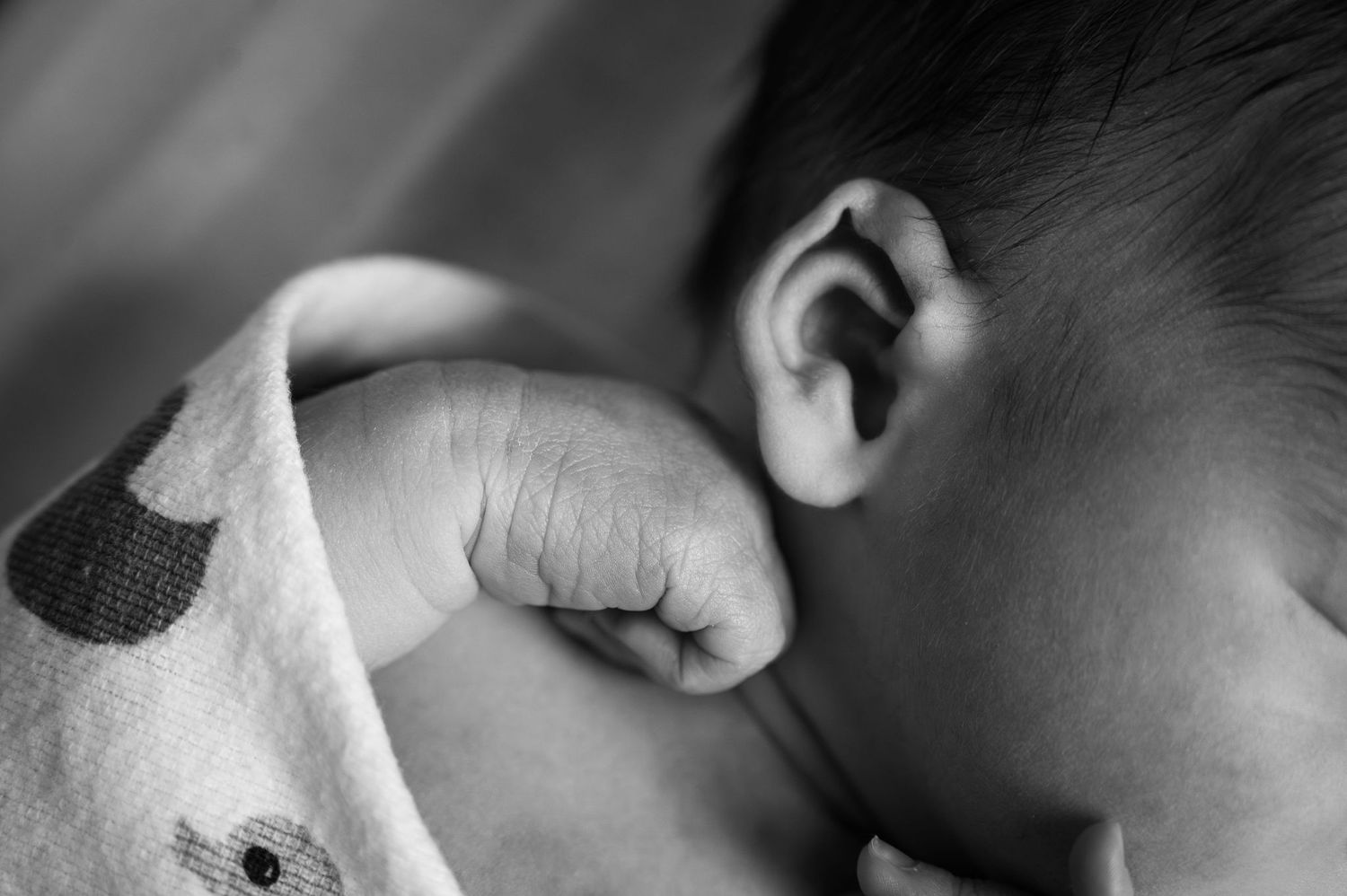 Black and white close-up of a newborn’s curled fist during an in-hospital Fresh 48 session in Columbus, Ohio.