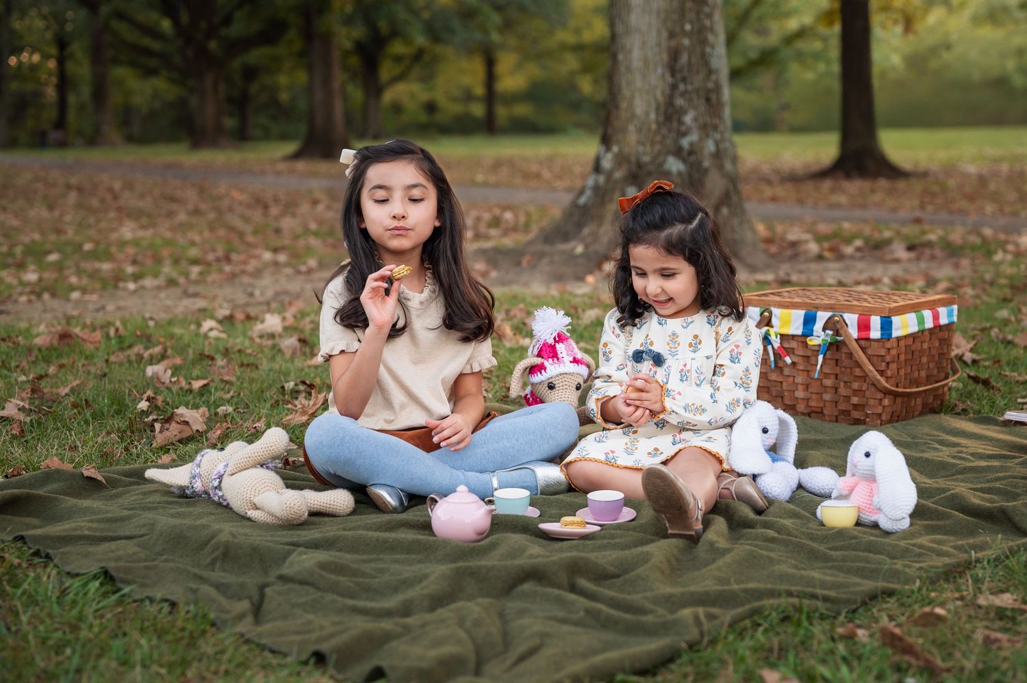 Two young sisters enjoying cookies and pretend tea with crocheted bunnies and a picnic basket | lifestyle family session.