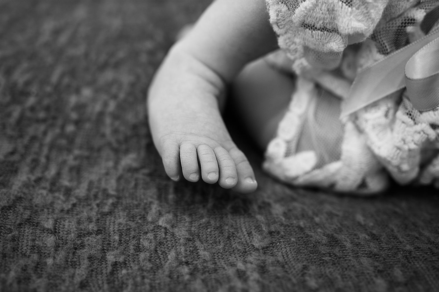 Black and white detail of baby toes in lace wrap—Westerville newborn session captured with timeless softness
