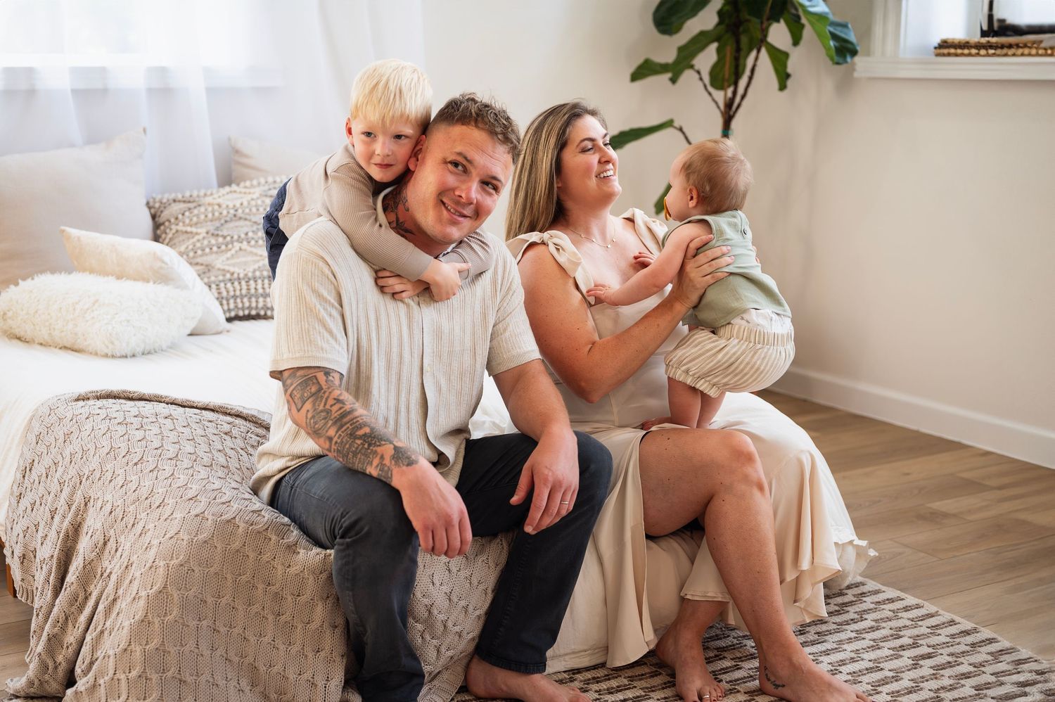 Lifestyle studio family session with parents smiling and playing with their young children in Westerville.